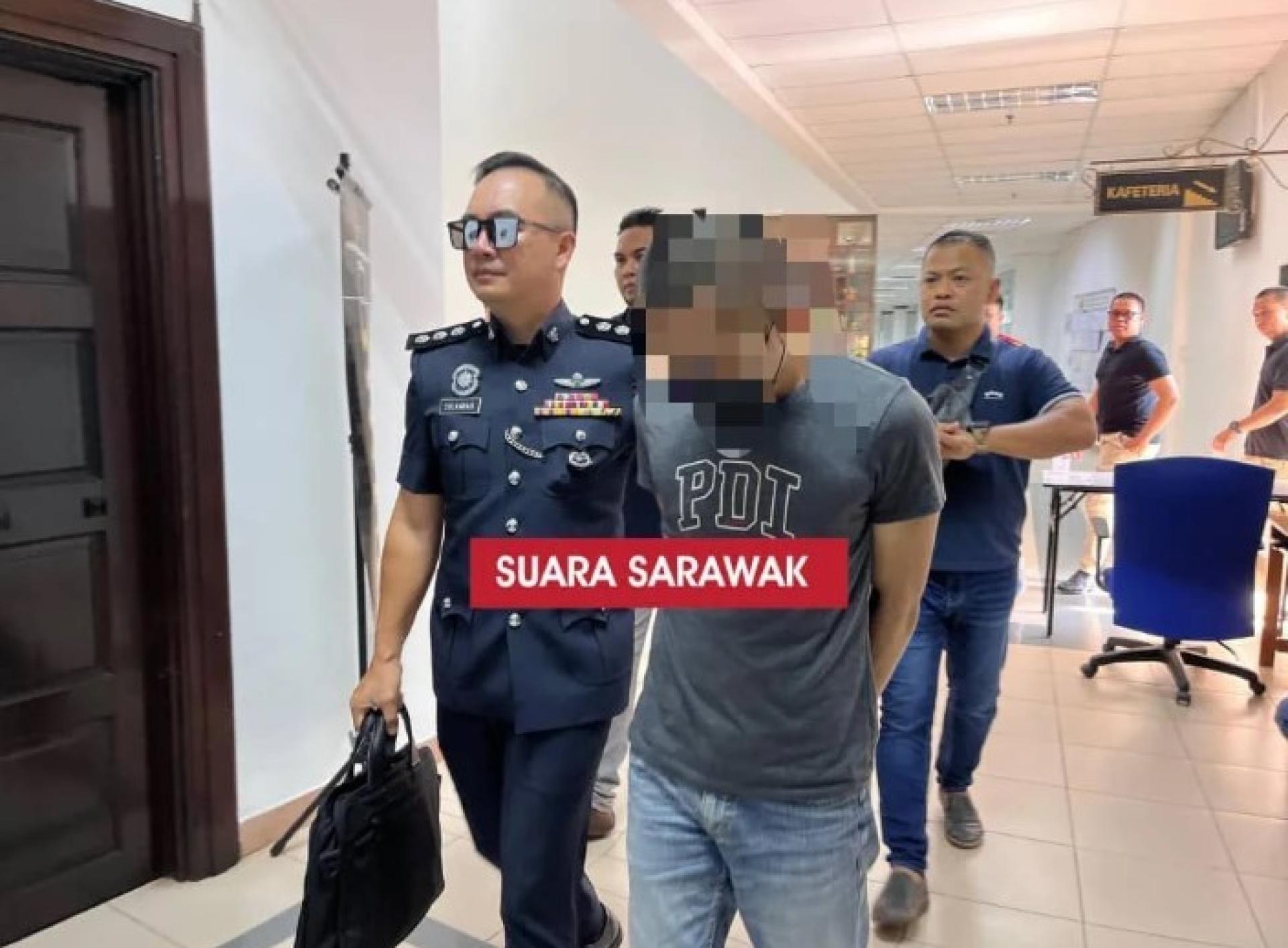 被告在警官ASP西尔瓦里尤斯·戈波押送下，步入地庭2号法庭出席案件提讯。