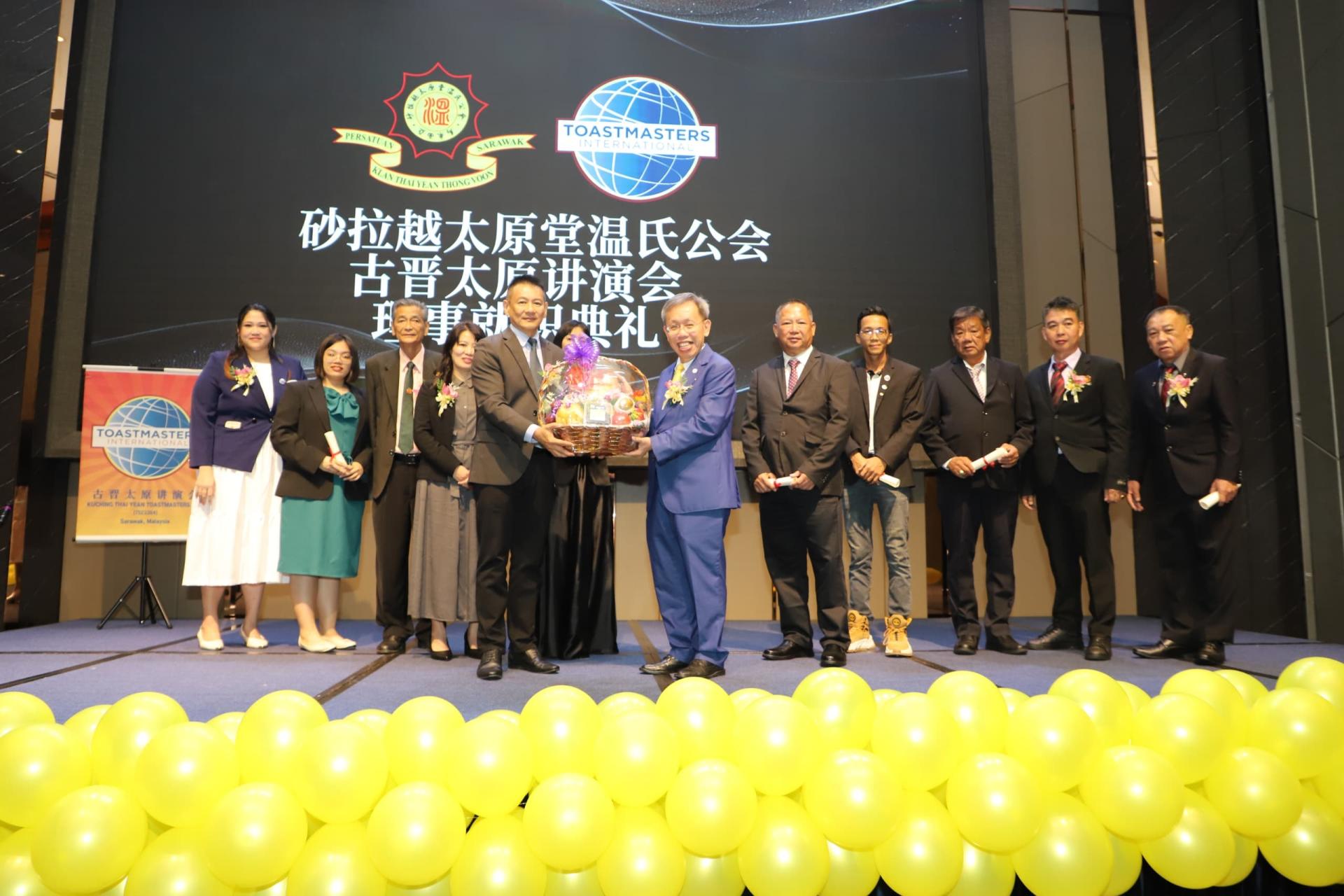 温德新（前左）赠送礼篮予沈桂贤。