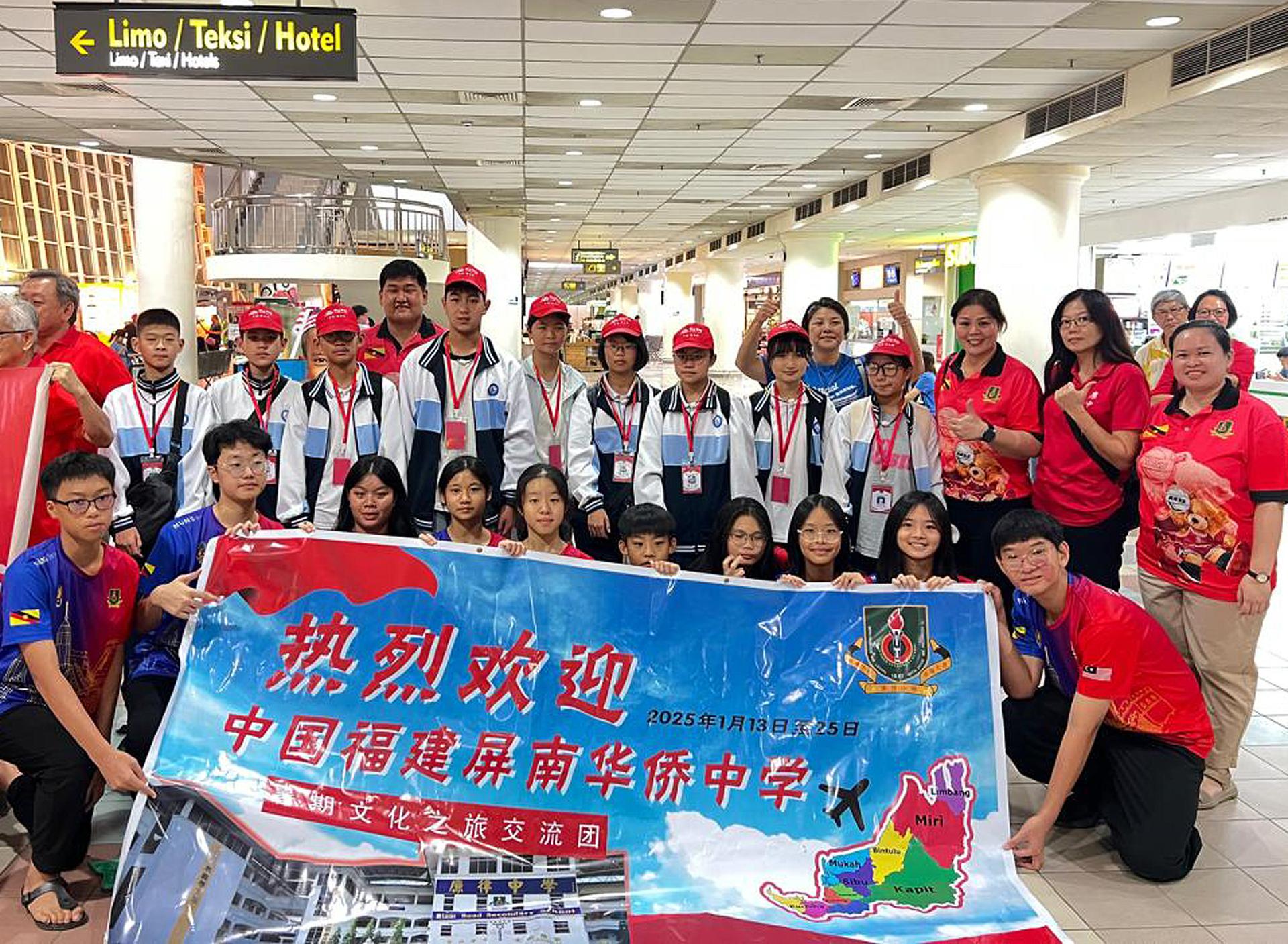 中国福建屏南华侨中学一行26人抵赴美里机场，获廉律中学校长江佩娟（后排右3）率队热情迎  接。