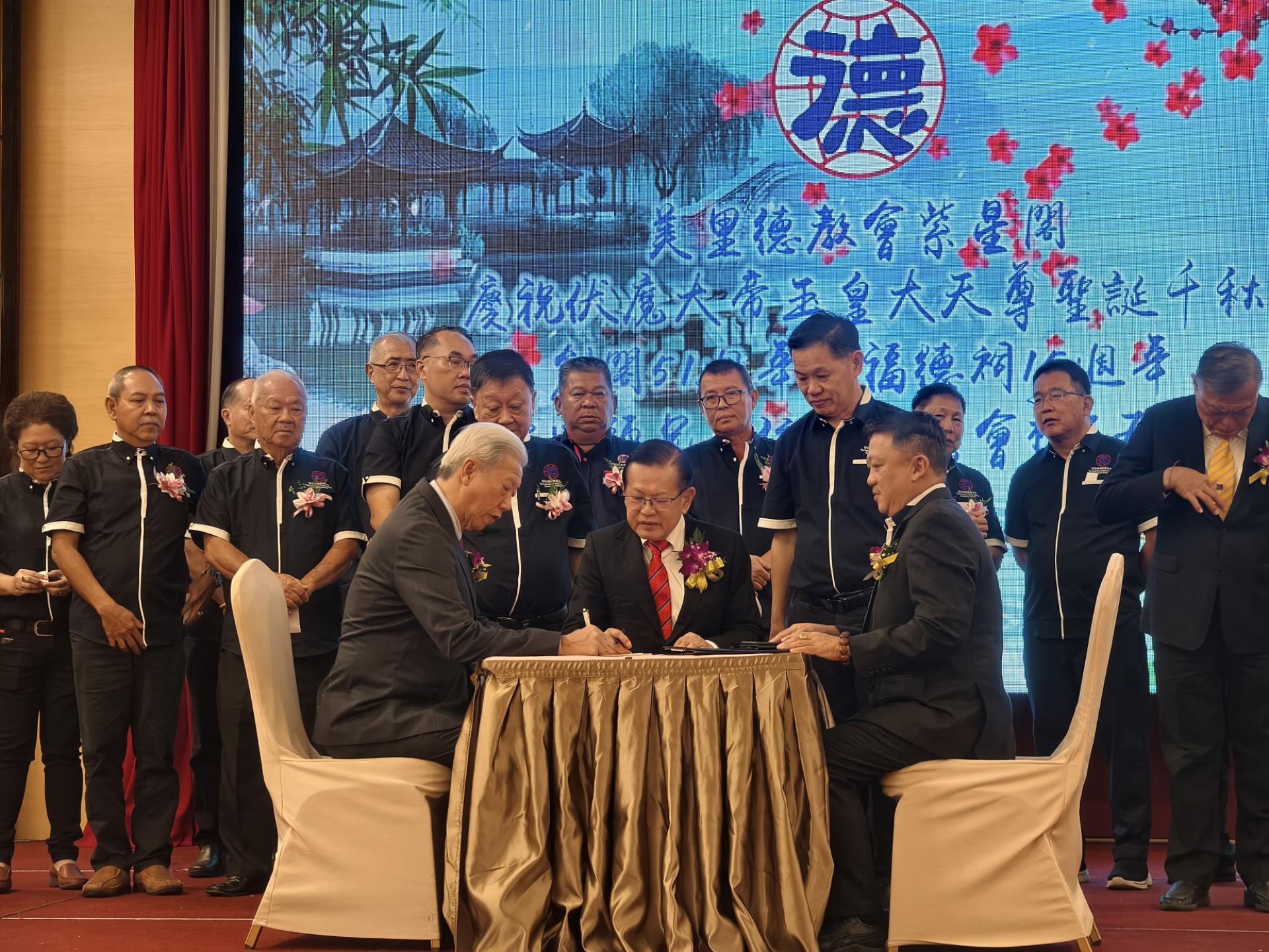 砂拉越德教联合会第3届理事宣誓就职典礼，署理会长贝清湛（左）在监誓人拿督斯里李景胜（中）及会长郭翼昇（右）见证下，在宣誓书上签名。