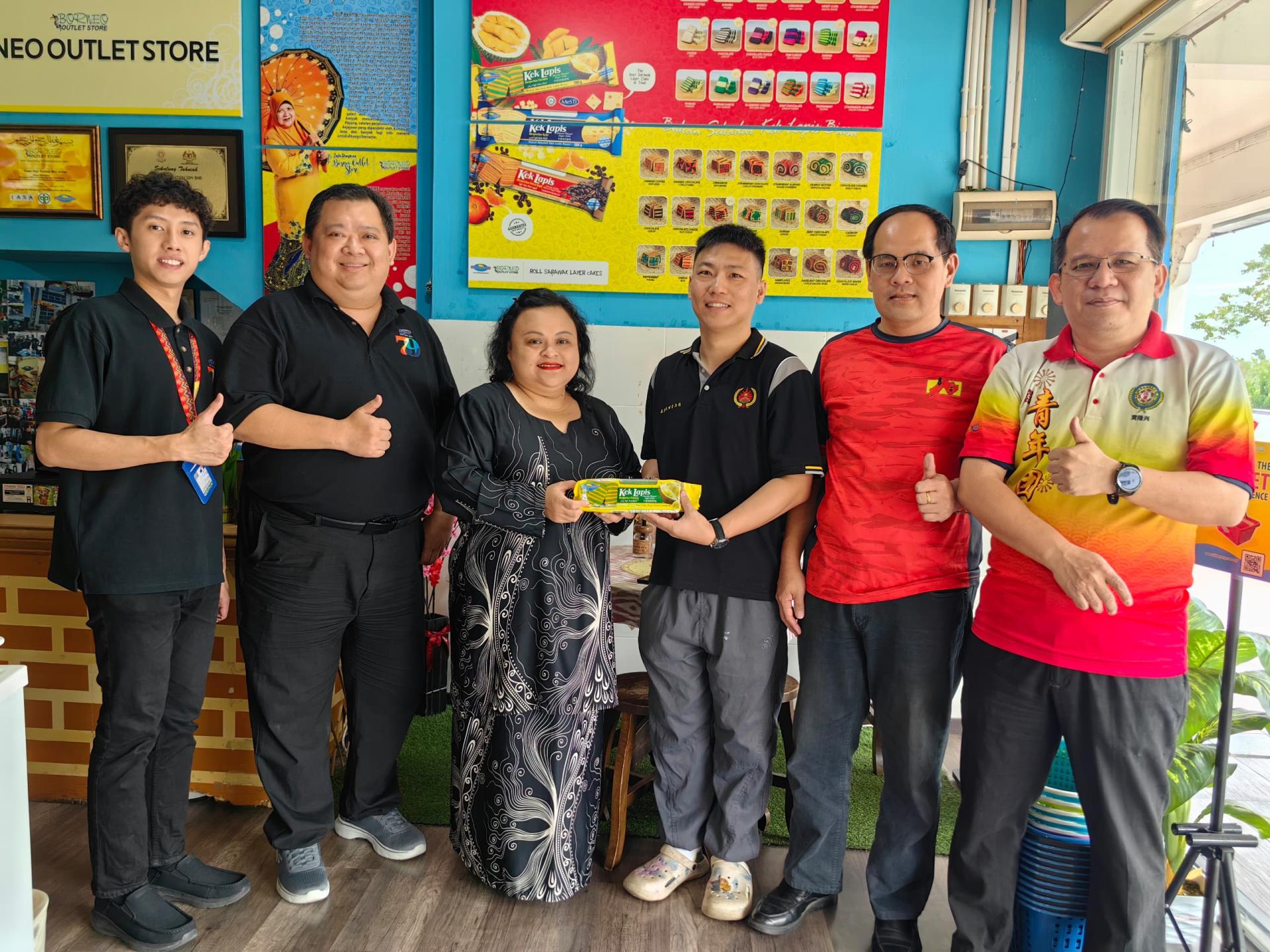 Siti Payung代表罗拉（左3）移交赞助品予美里大埔同乡会青年团策划兼筹委总务朱景兴。