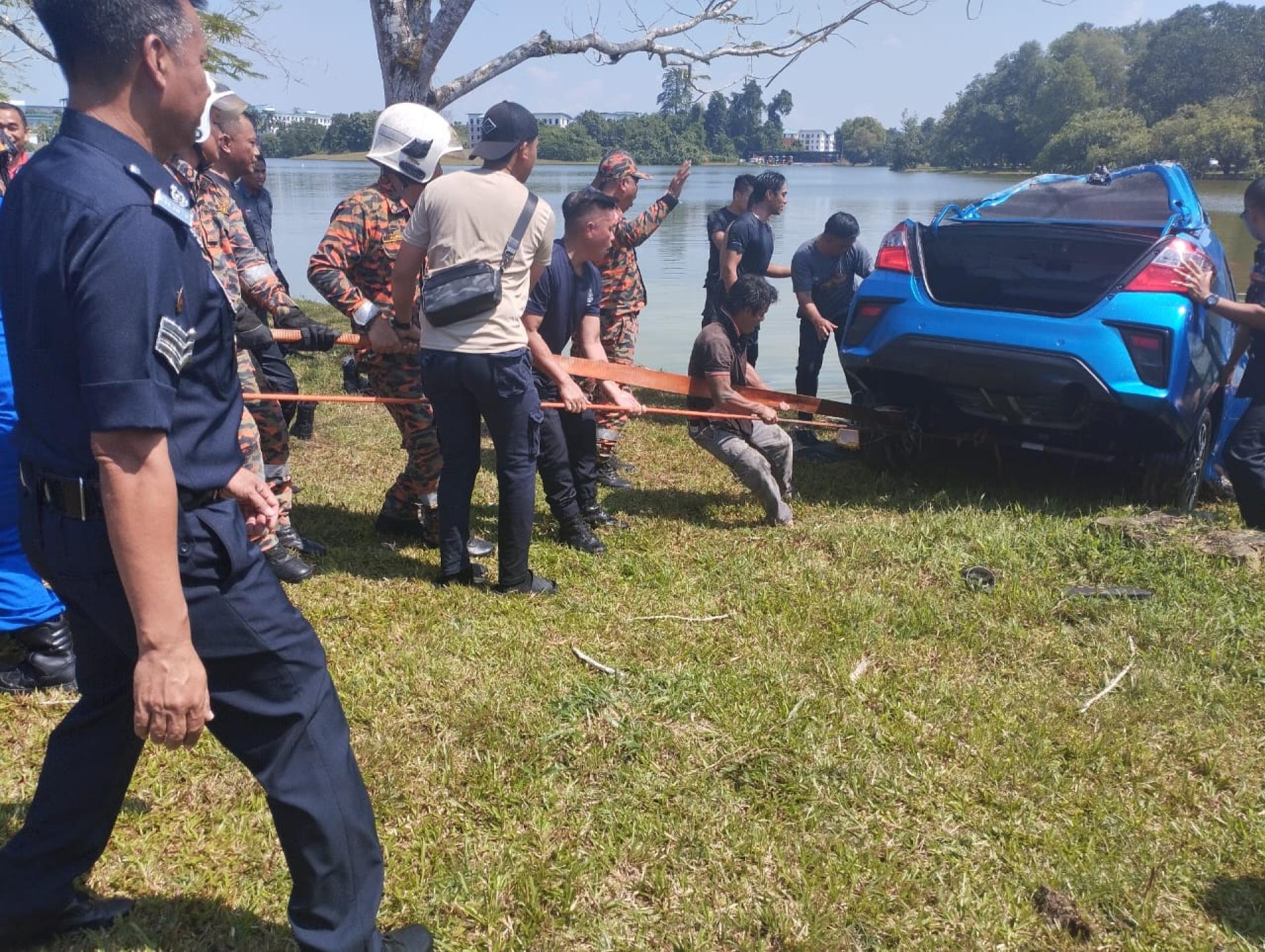 The car being pulled out of the lake by firefighters and the public.