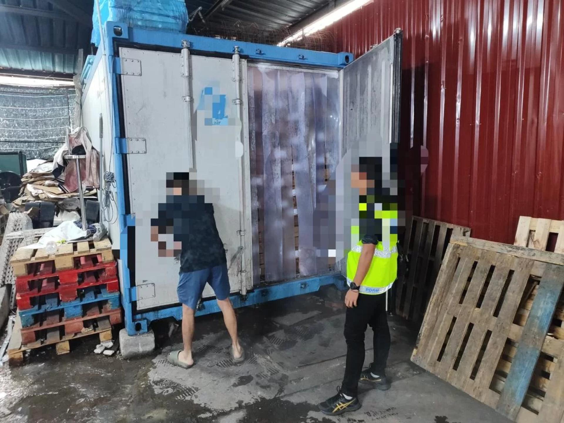普通行动组警员正指示一名嫌疑人打开冷冻柜接受检查。