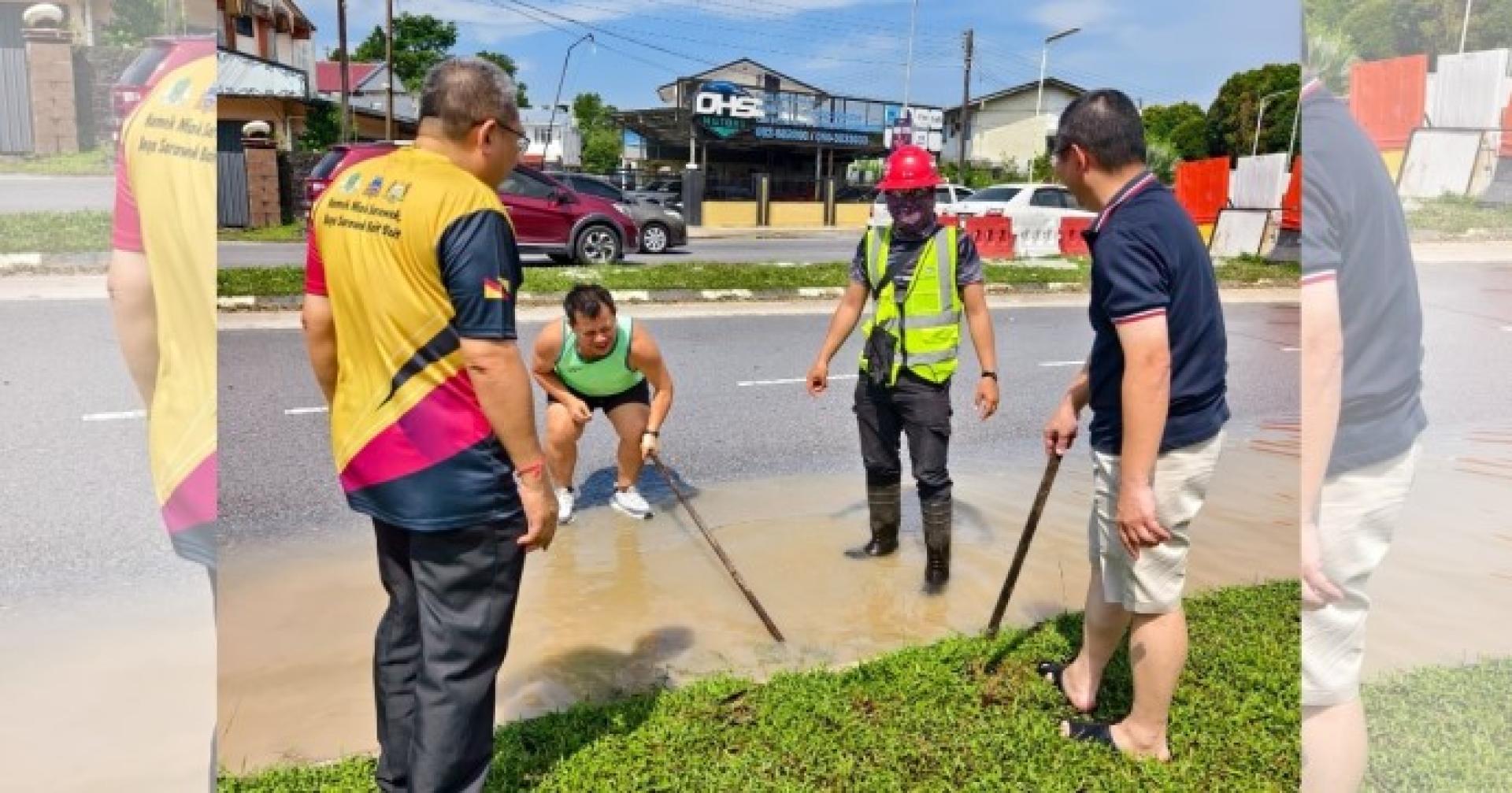 2025年7月22日，黄鸿圣（左）与市议员及工作人员视察旺阿维路交通灯附近水管爆裂现场，维修工作正展开中。