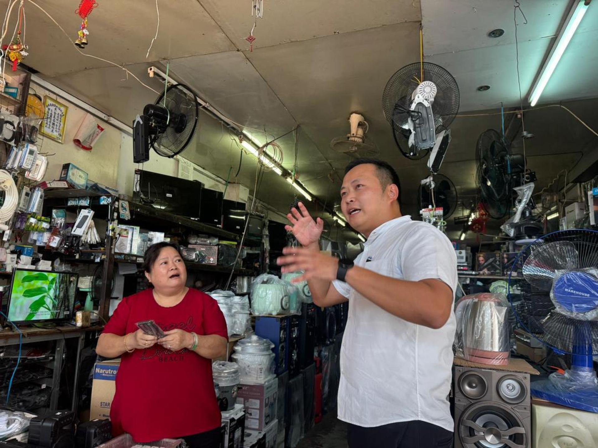 砂商用车辆注册局主席江峰年（右）与当地商家交流，了解他们对短程巴士的看法。