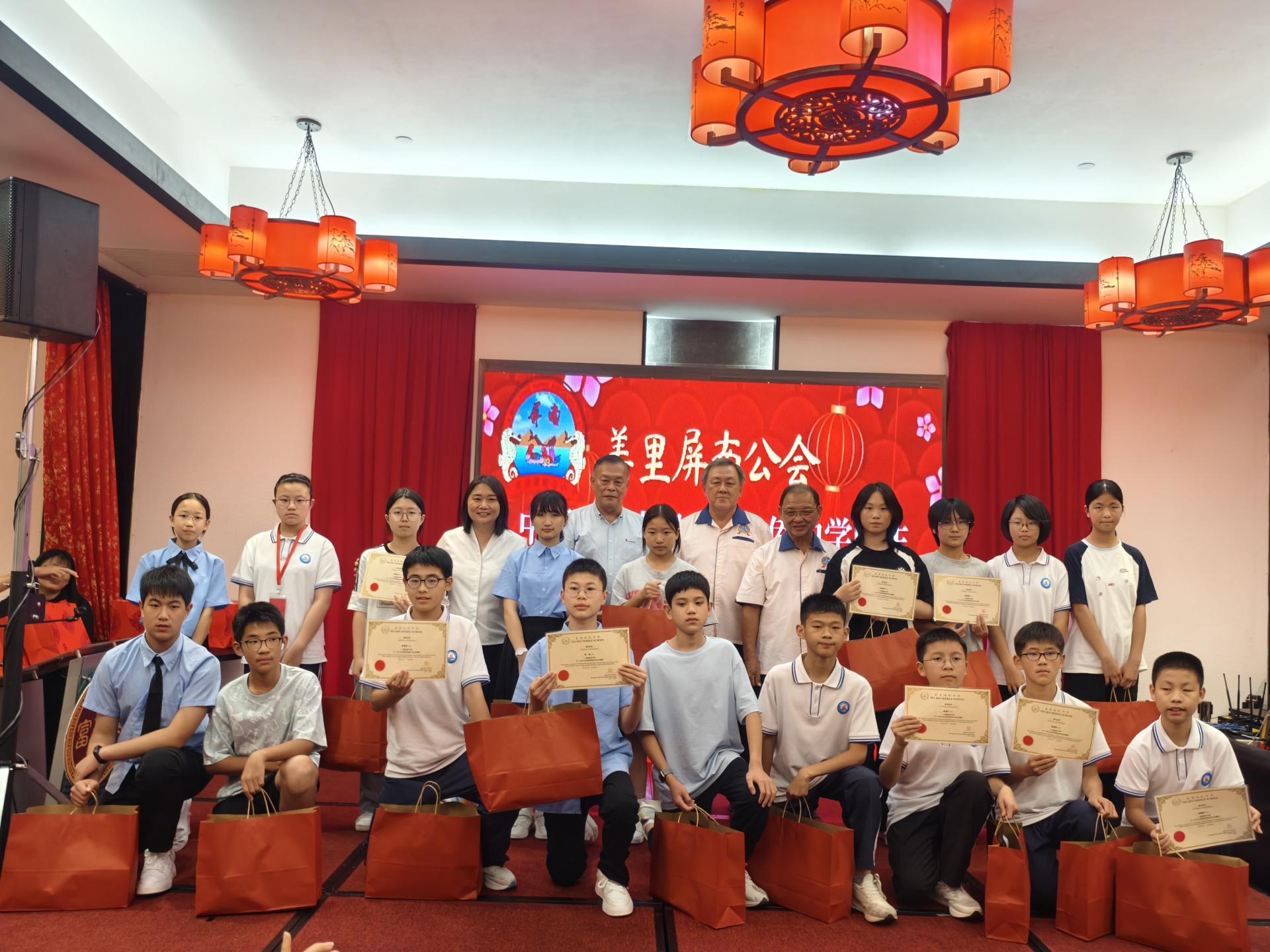 培民中学赠送纪念品给全体中国福建省屏南县华侨中学同学合影。后排右5起为美里屏南公会署理会长拿督斯里黄有辉，会长陈家兴，培中董事长许为隆（左）及培中校长贝美娇。