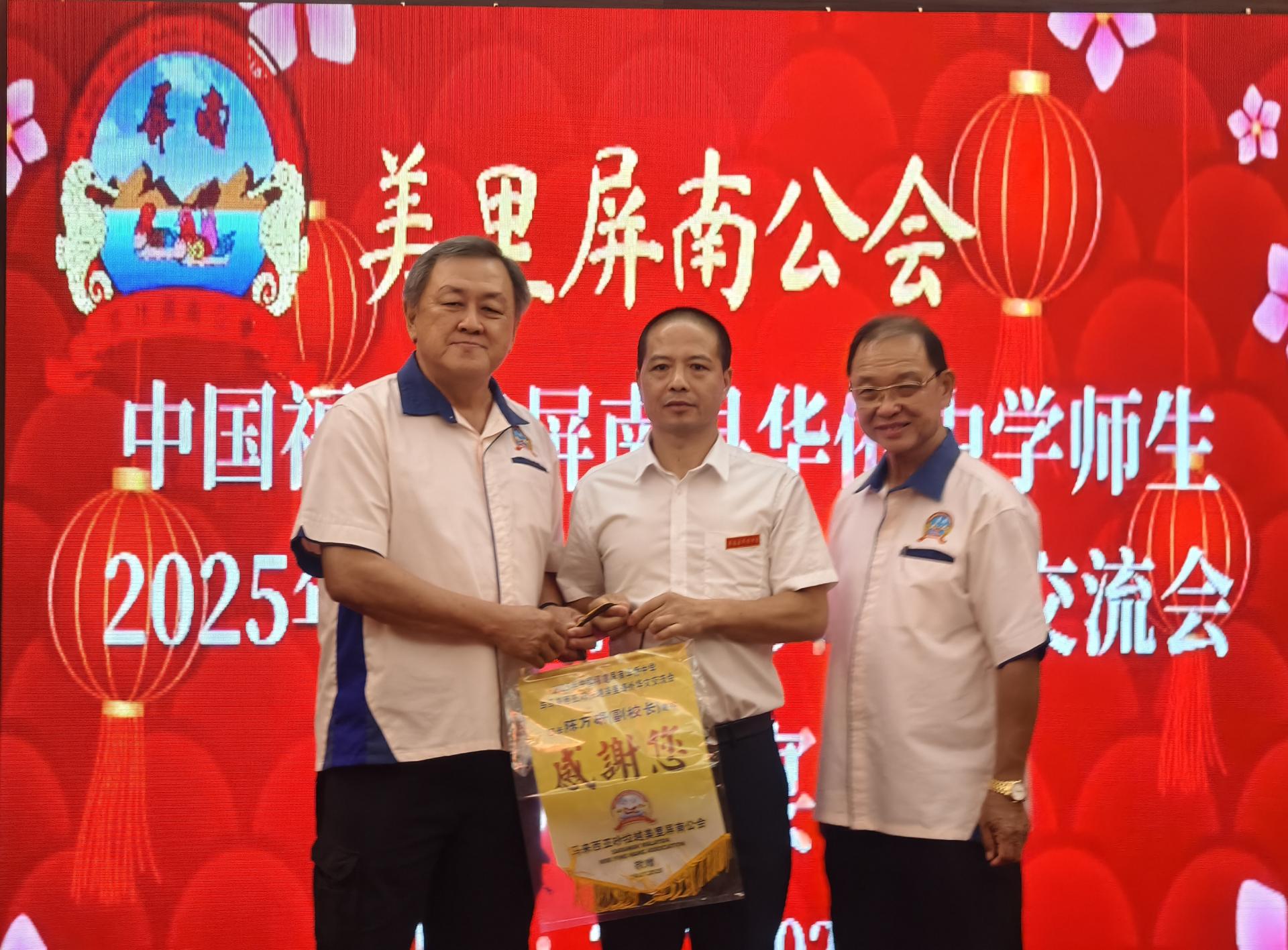 美里屏南公会会长陈家兴（左）颁发纪念品给2025年马来西亚海外华文交流团领队陈万研。右为拿督斯里黄有辉。