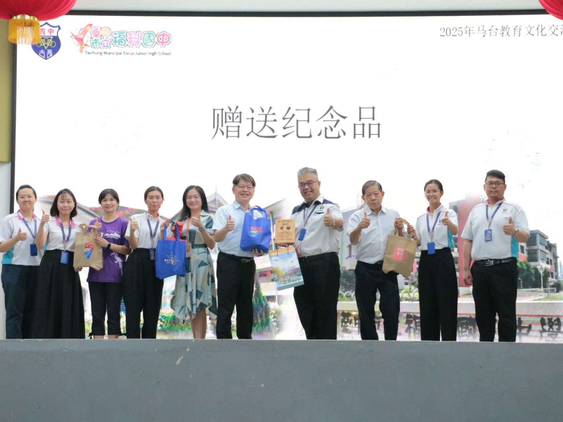 四中校长官晨阳（右4）及福科国中校长林福裕（右5）互赠纪念品。左起：四中副辅导主任曾诗涵、副教务主任黄小珍、福科辅导主任赖妙芬、四中教务主任蔡秀凤、福科国中家长会名誉会长梁慧婷、顾问房其颂、四中联课主任莫静瑶及辅导主任杨益堃。