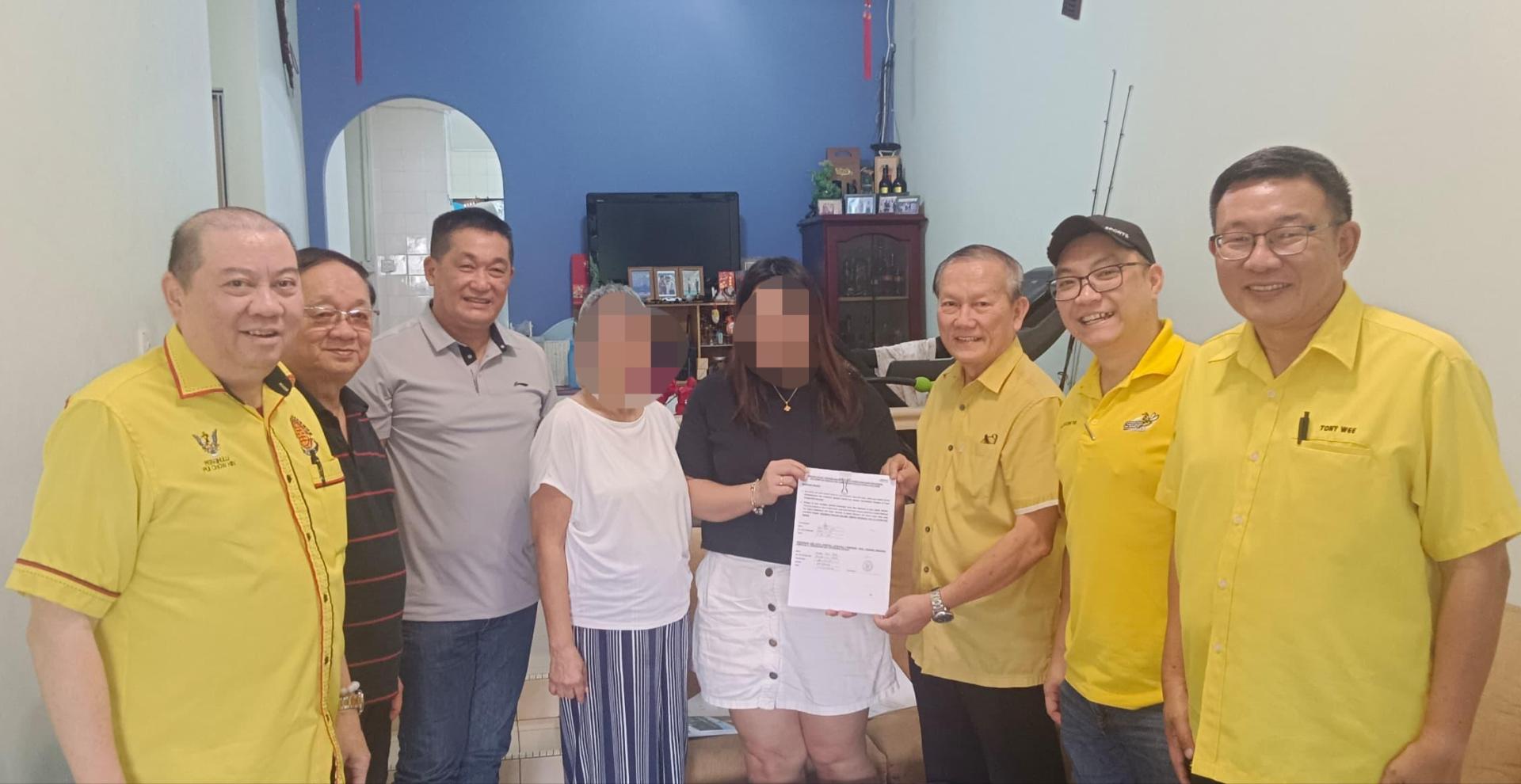 携手献爱心团队顾问本固鲁严安干（右3）代表将福利局所批准的信函，移交给受惠者家人。在场左起为贝朝兴、林瑞钊、施志豪、汪女士及其女儿。右起为黄文益和劉儱語。
