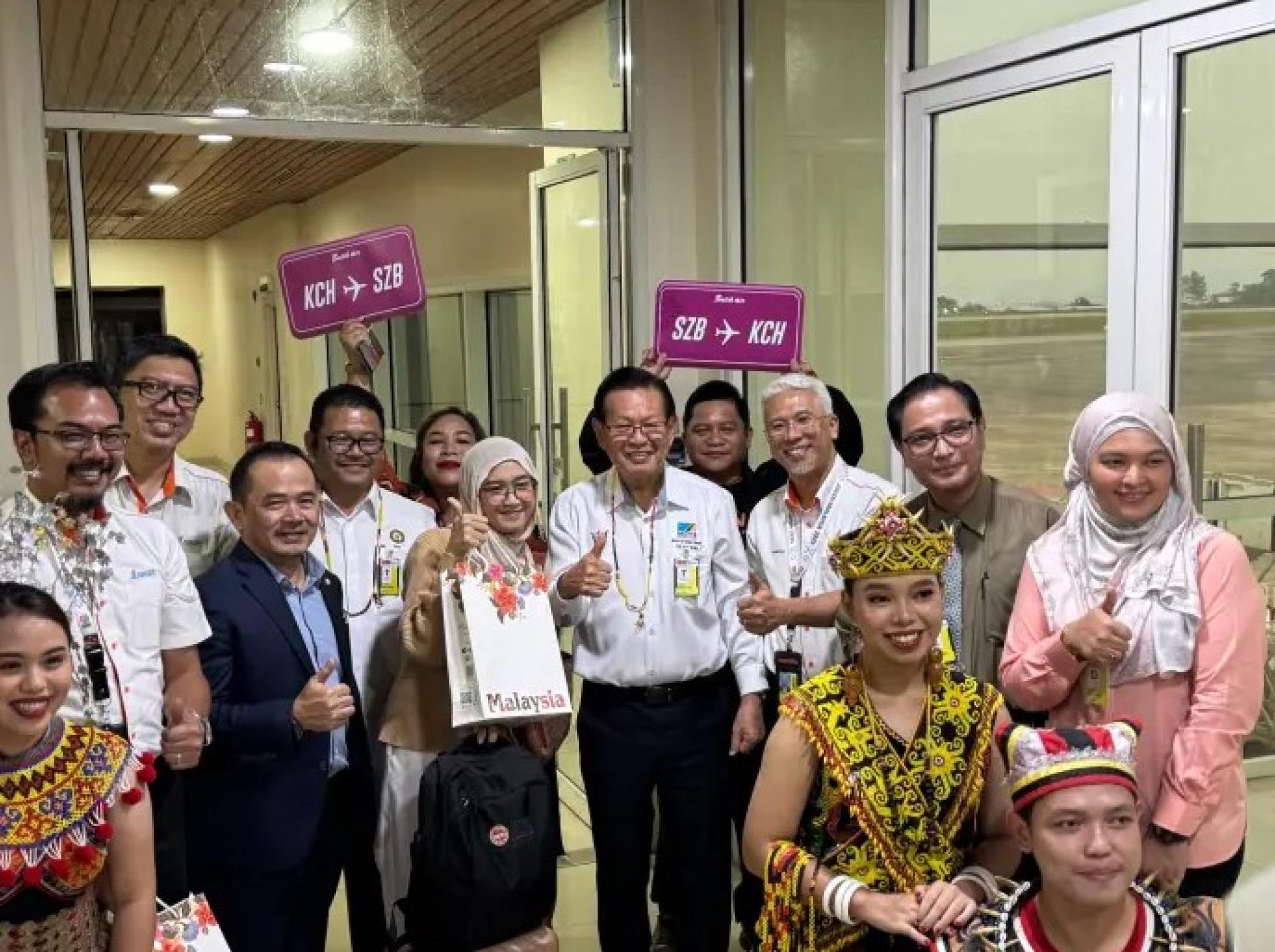 Lee (second row, fourth left) joins other officials in welcoming passengers of the inaugural Subang–Kuching flight at the Kuching International Airport VVIP Terminal on July 28, 2025.
