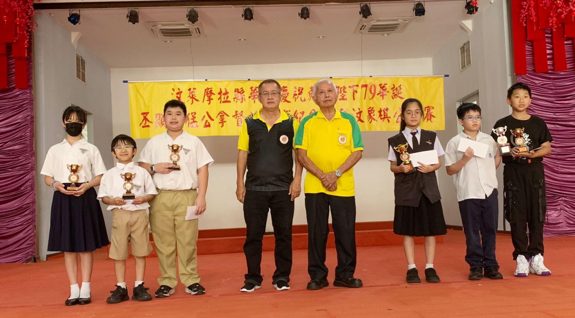 小学组优胜棋手与主席陈仙福（右4）第一副主席洪应新（左4）合影。