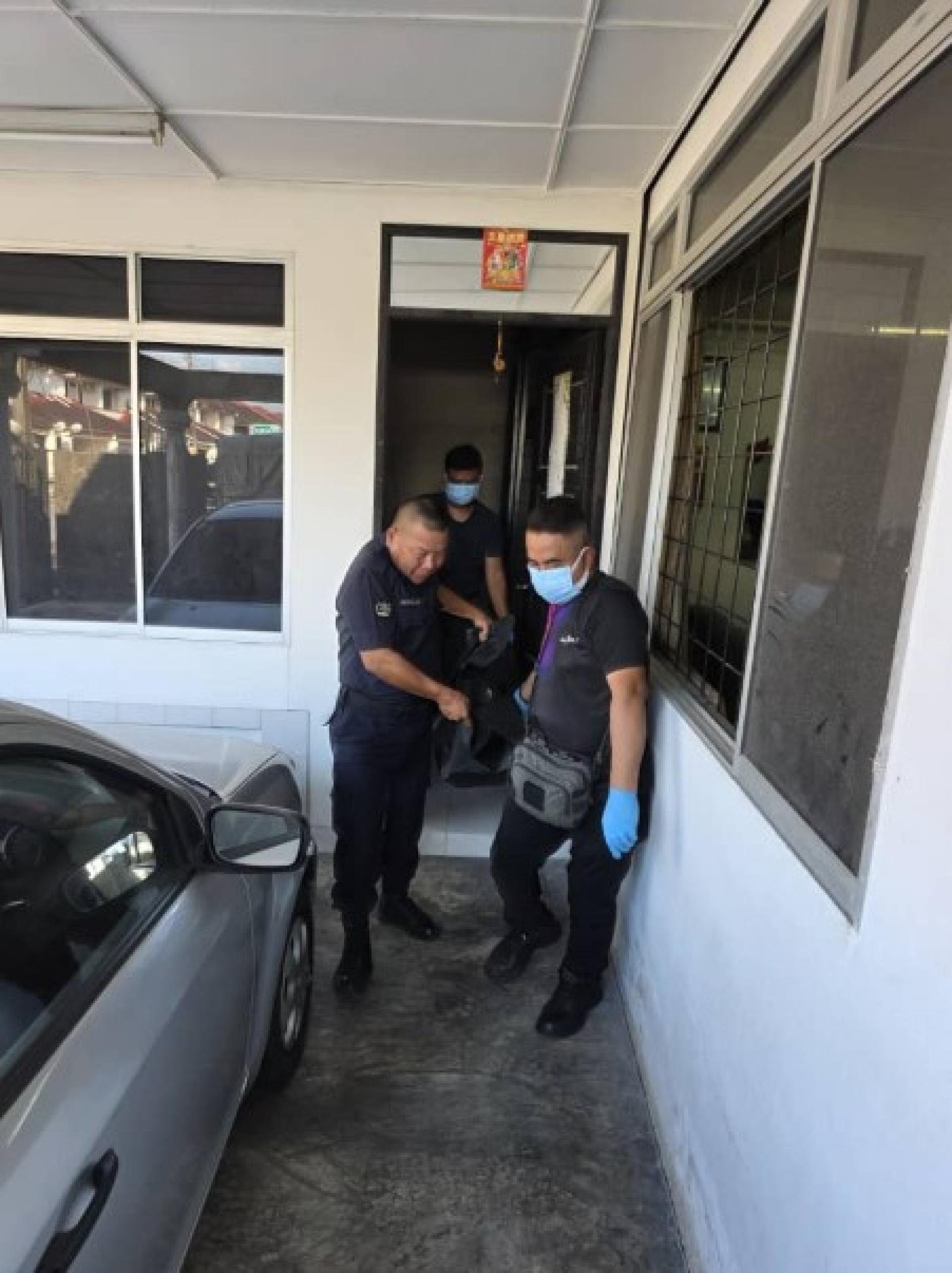 警方将死者遗体抬出屋外。
