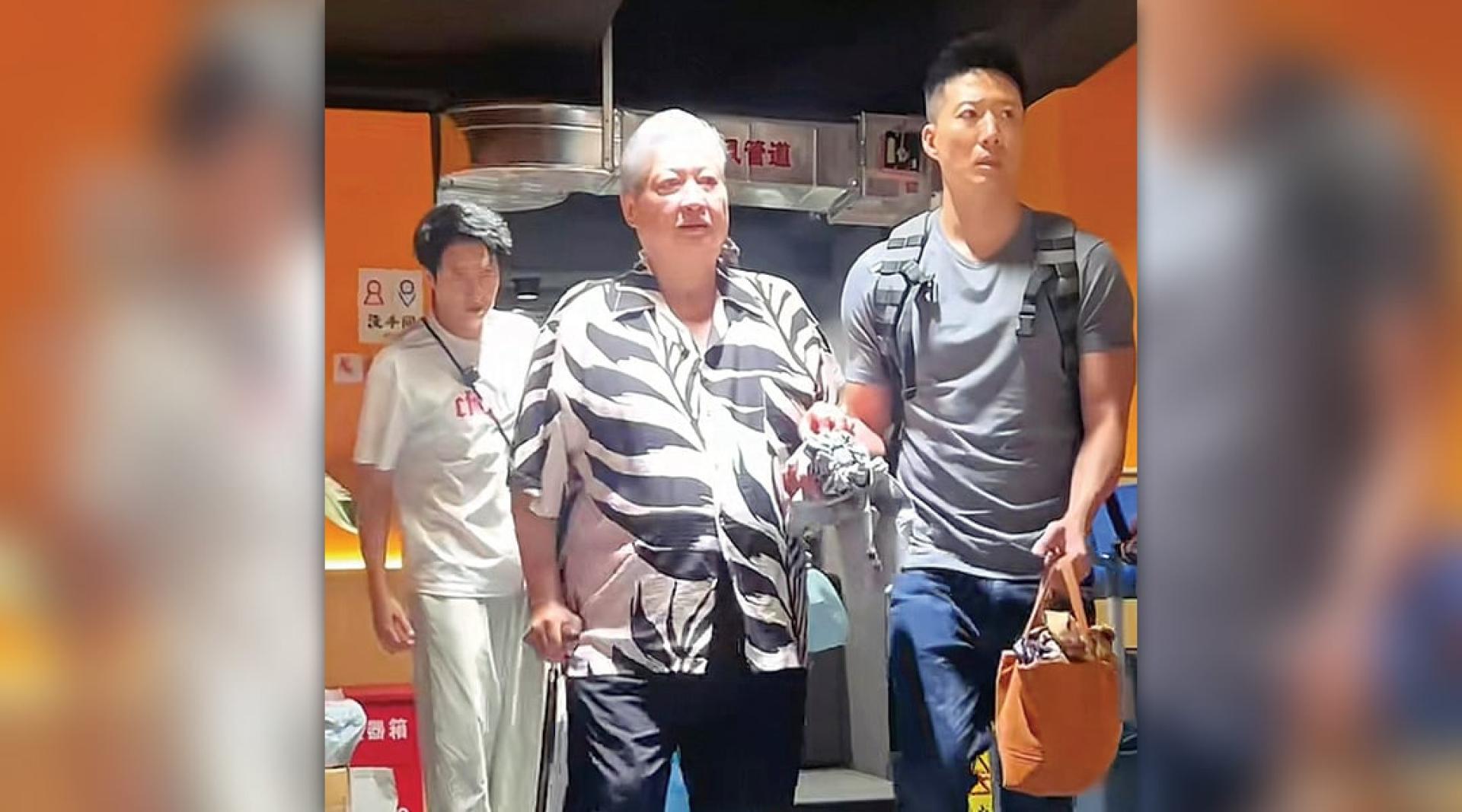 洪金宝（中）撑拐杖走进火锅店，洪天照（右）在旁陪同。