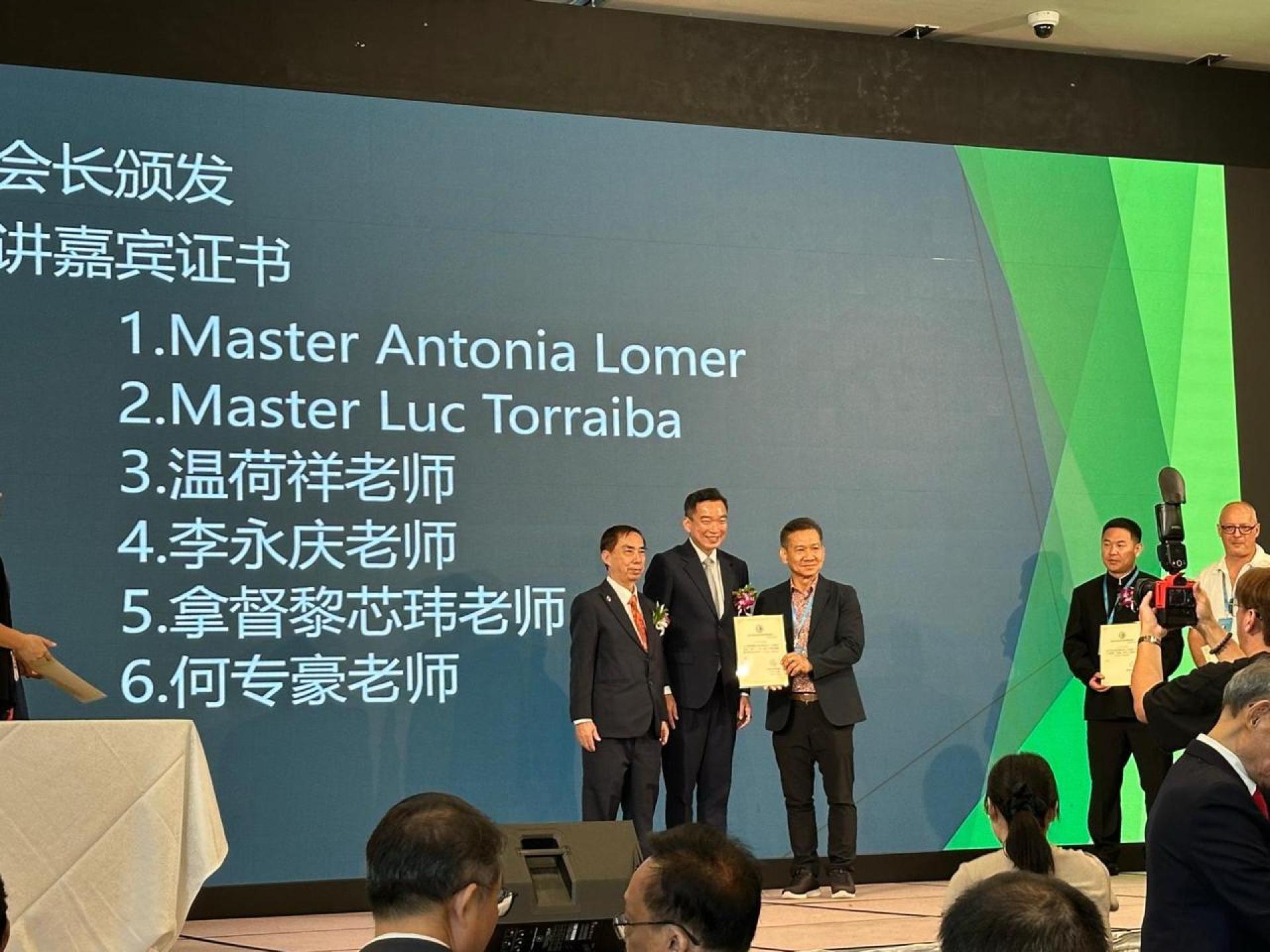 新加坡易经研究协会会长沈树圭颁发表扬证书予“世界易学联盟”汶莱区分会易经风水师拿督黎芯玮，中为新加坡社会与家庭发展部兼律师部高级政务次长蔡瑞隆