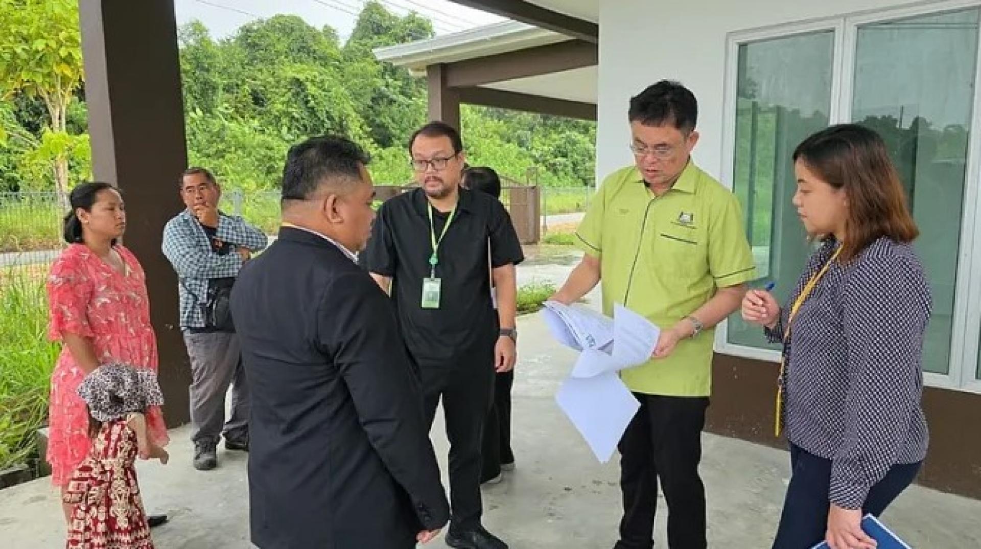 巴达旺市议会主席陈开（右2）于2025年8月4日出席古晋绿林花园住宅计划现场的入伙准证移交仪式。