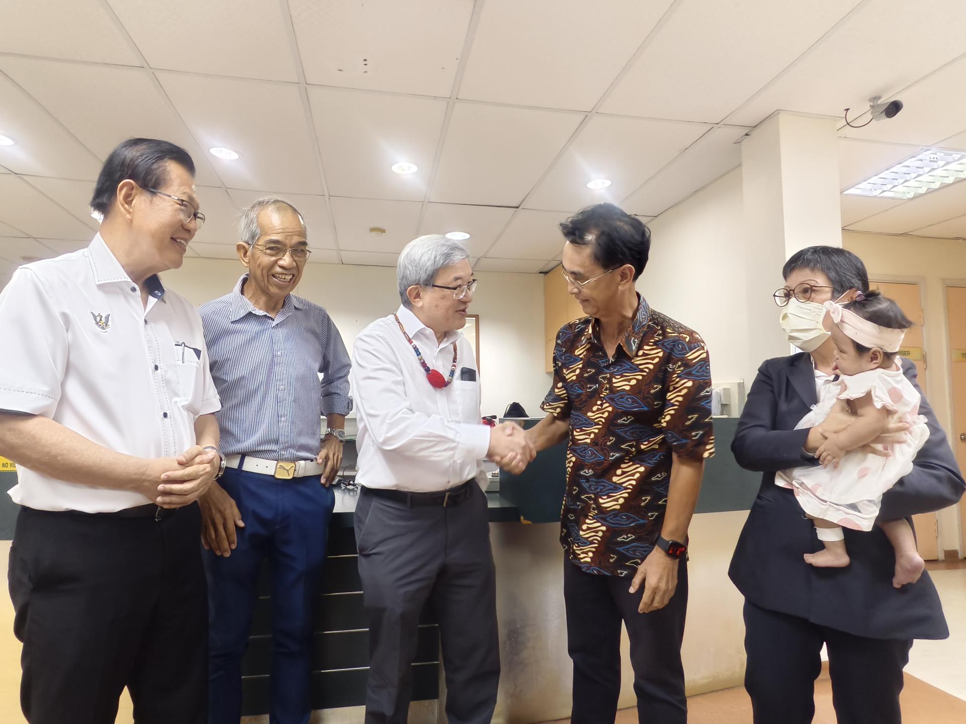 砂拉越裂唇及裂颚援助协会主席菲立拉惹医生（右2）赠送纪念品给即将退休的知名整形外科医生陈锦光（左3），并握手表达感谢。左起为砂交通部长拿督斯里李景胜，Selasa Pacific Hospital 医疗总监罗兰多玛迪医生;右为何秀春护士长。