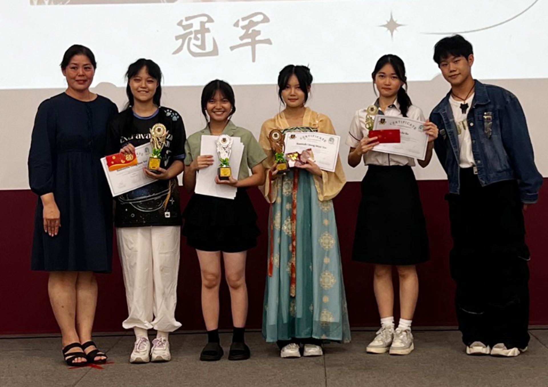 廉中校长江佩娟（左1）颁奖给环保创意手工赛中学组得奖者合影。右为筹备会主席 刘力溱。