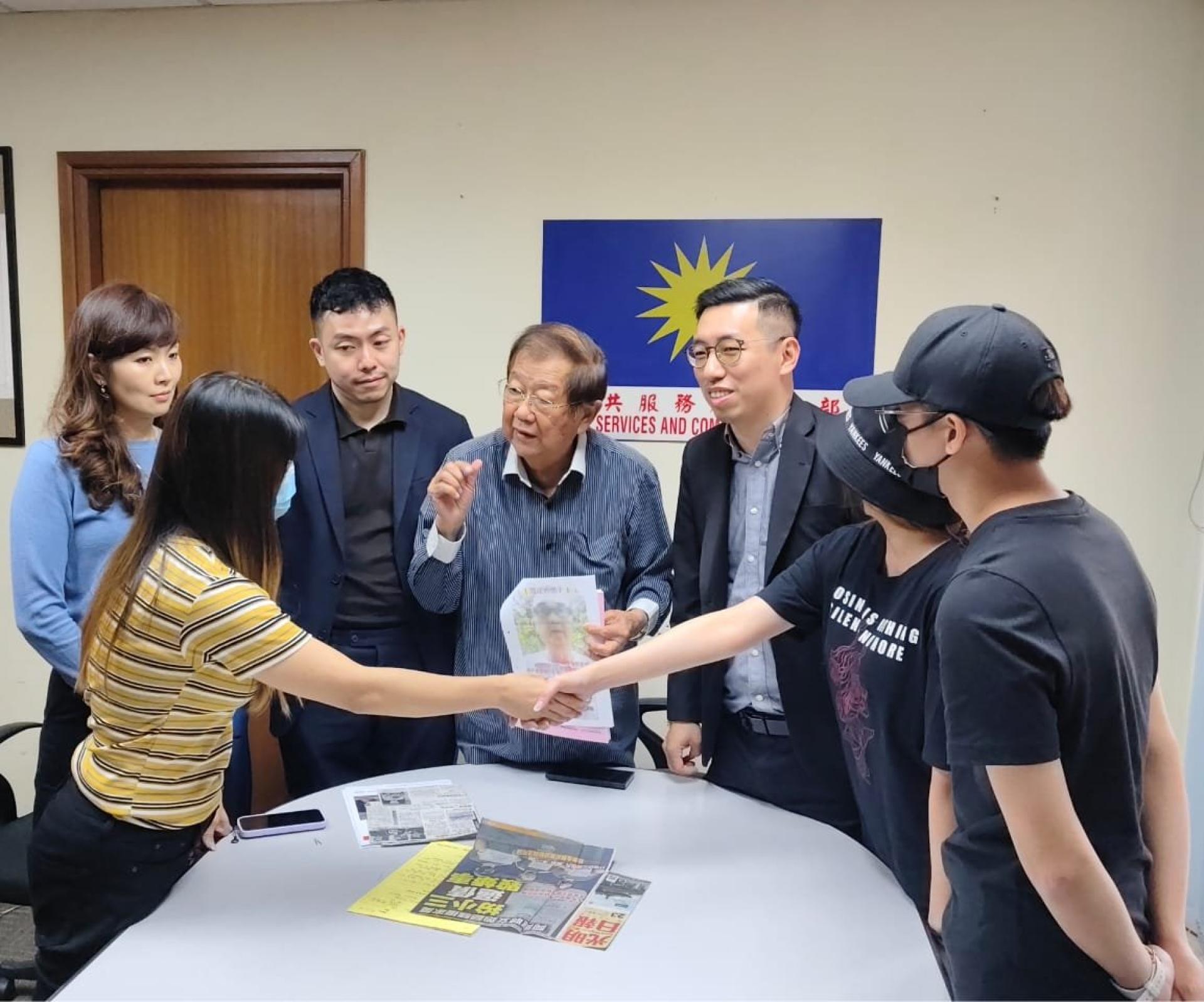 洪女士（左）与黄姓男子家属握手、左起陈其翔、张朝盛、张天赐与陈国勇。