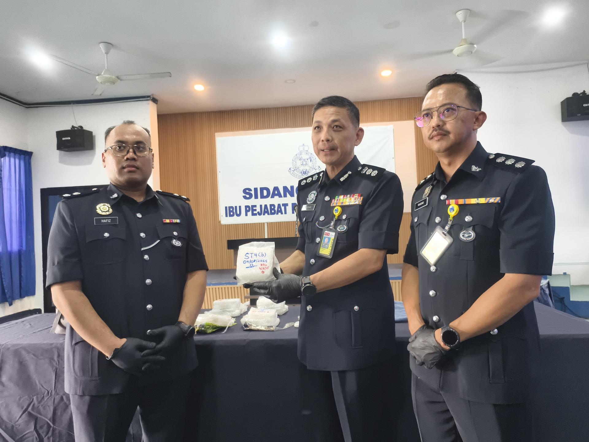 美里警区主任李炳强（中）展示警方起获的冰毒。左为查案官莫哈末诺哈菲祖丁，右为美里毒  品罪案调查组主任雷祖安。