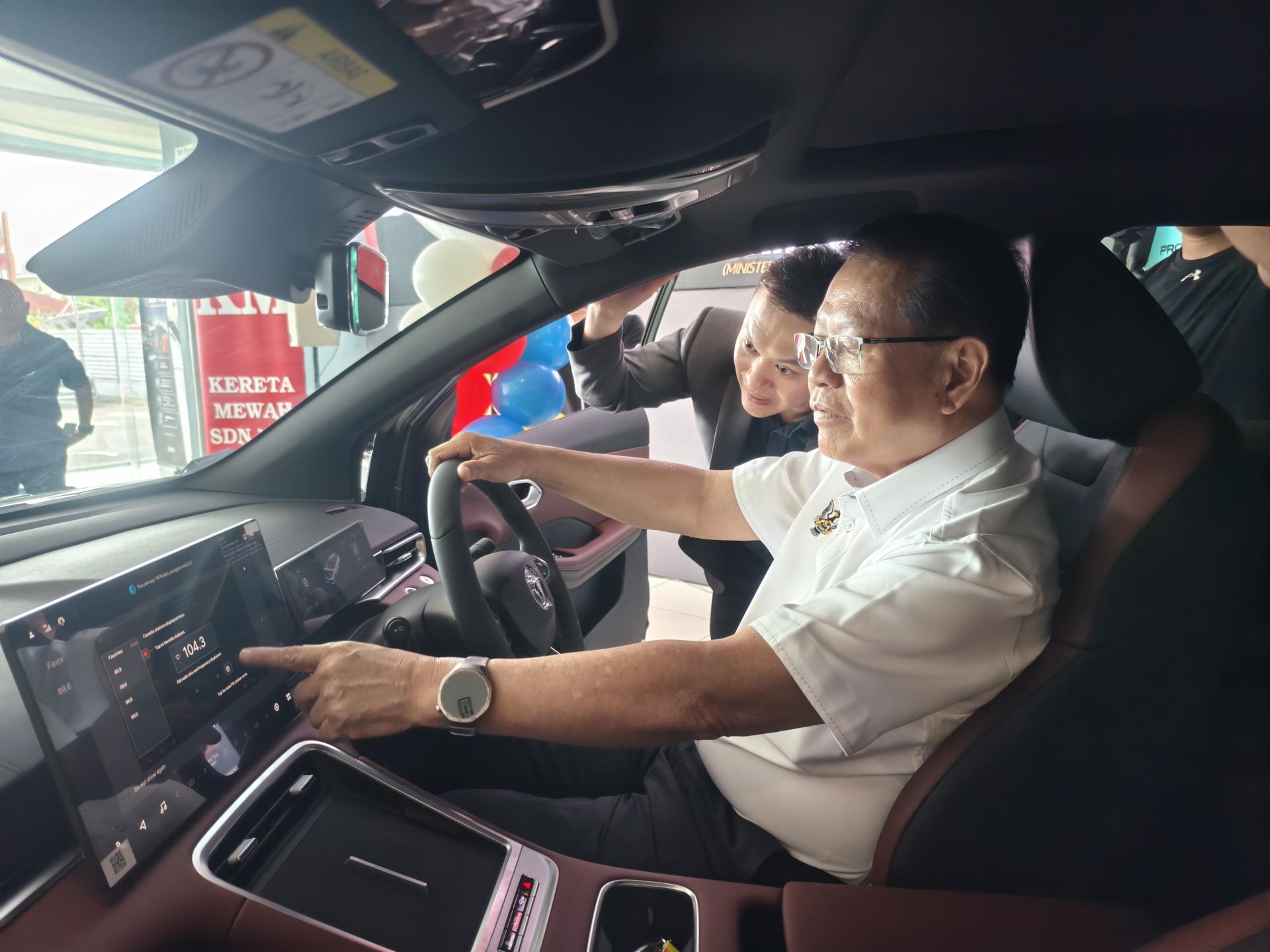 砂交通部长拿督斯里李景胜启动全新宝騰X50。旁为  Kereta Mewah有限公司总经理陈庆忠。