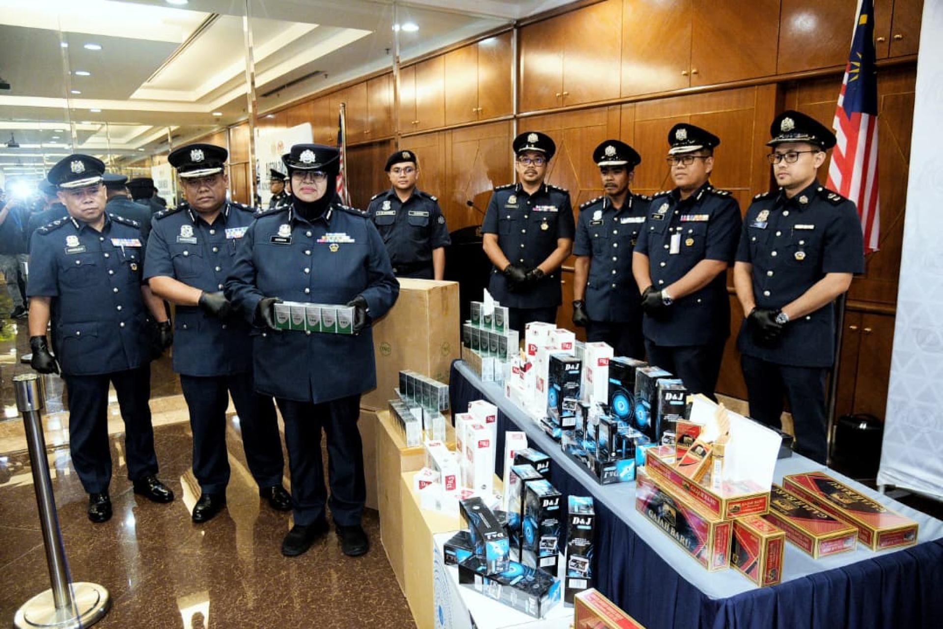 诺丽占（左3）与下属出示搜到的走逃税香烟。