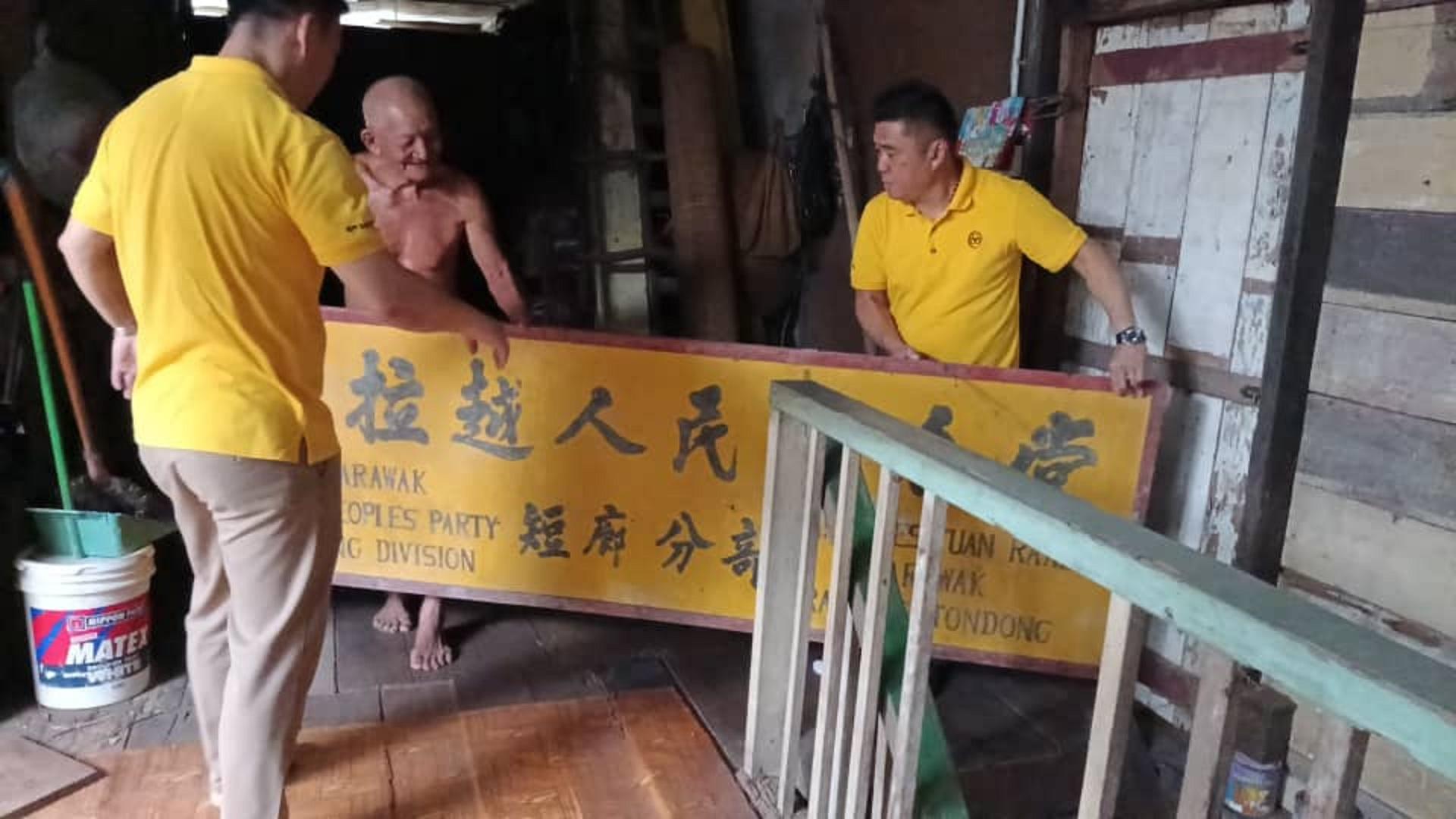 支部团队成员协助搬运保存多年的“老牌匾”，见证党支部历史传承与地方发展的印记。