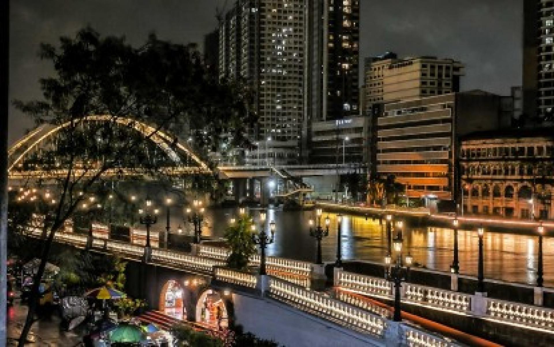 马尼拉王城区的照片显示，灯火通明的帕西格河滨步道。