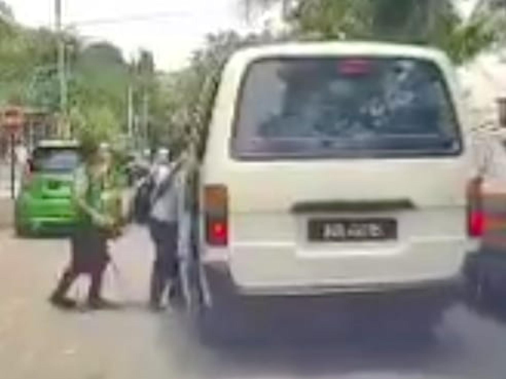 两名学生轮流登上缓慢行驶的客货车，险象环生。