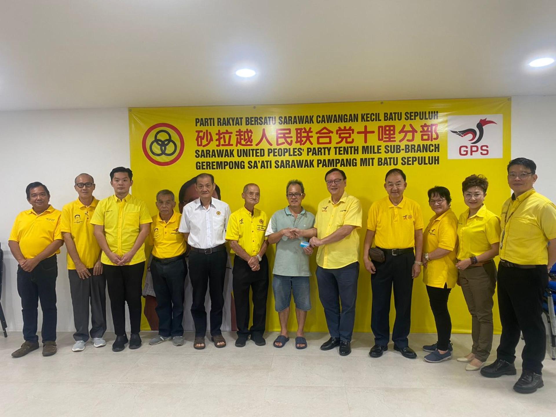 党支部主席拿督罗克强（右5）在其他党领导的陪同下，将其中一张入党卡移交给新加入的会员。