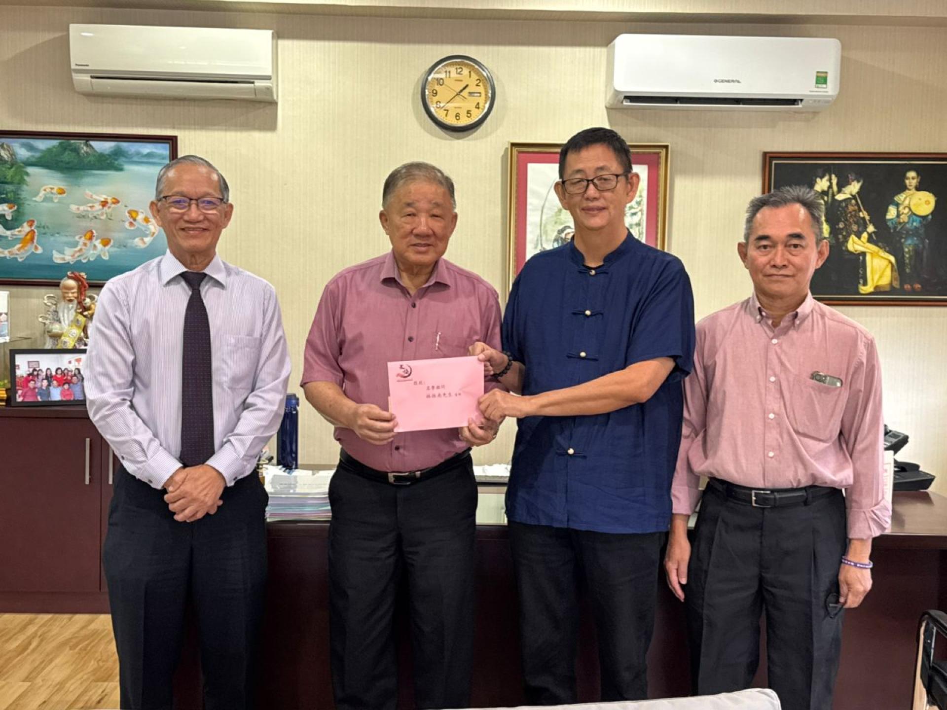 会长杨镇声移交邀请函予名誉顾问林振南、左一为副会长包平生、右一为秘书长刘坤彰。