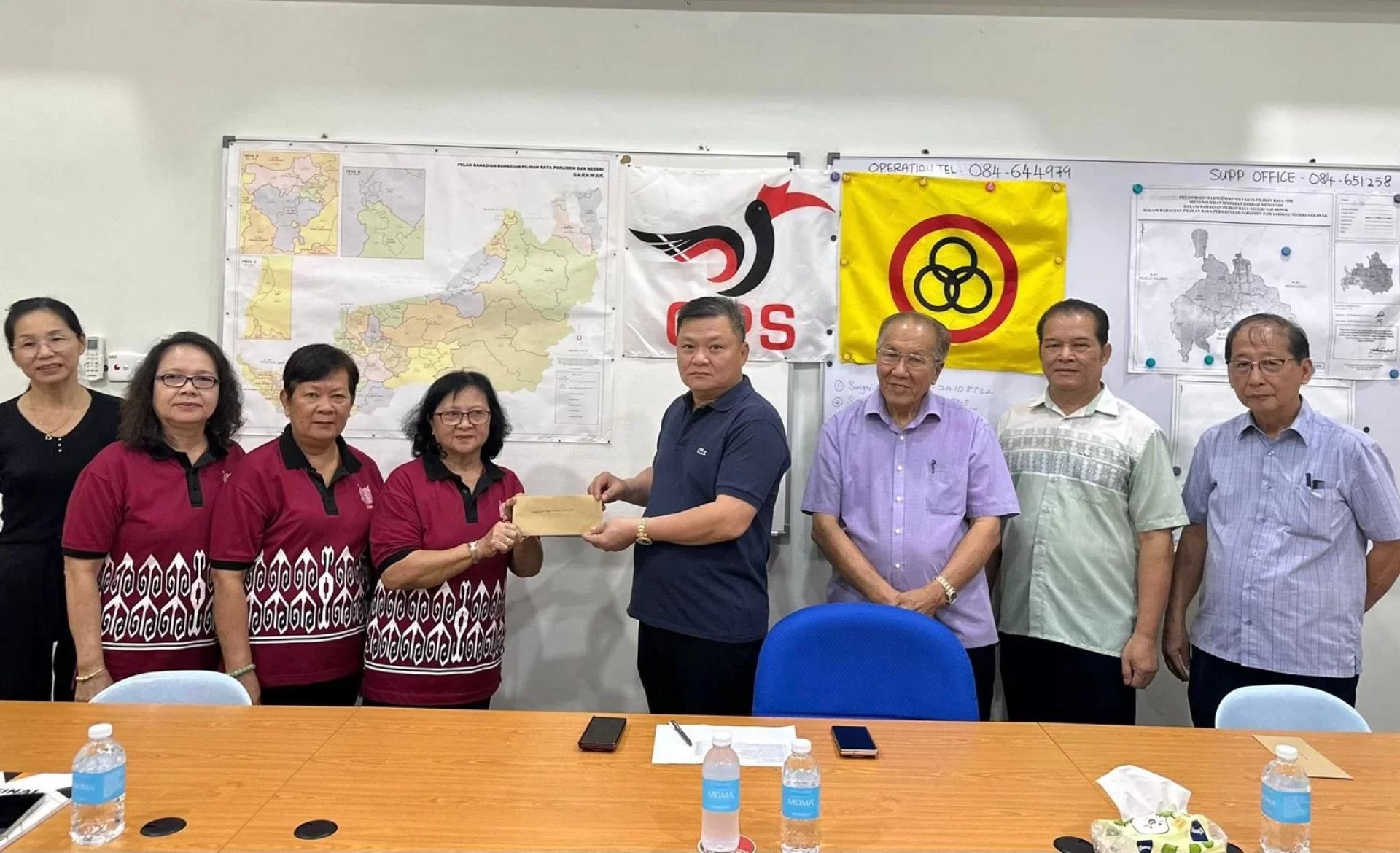 Huang (4th right) presents a cheque to one of the recipients.