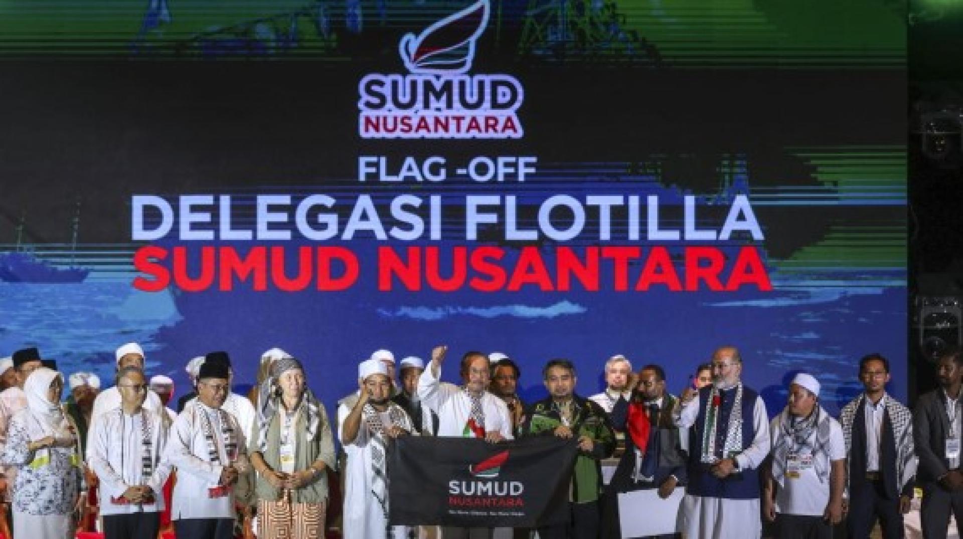 安华（右7）把“Sumud Nusantara”旗帜移交予MAPIM首席执行员沙尼阿拉比（右6），为加沙救援队主持挥旗礼。