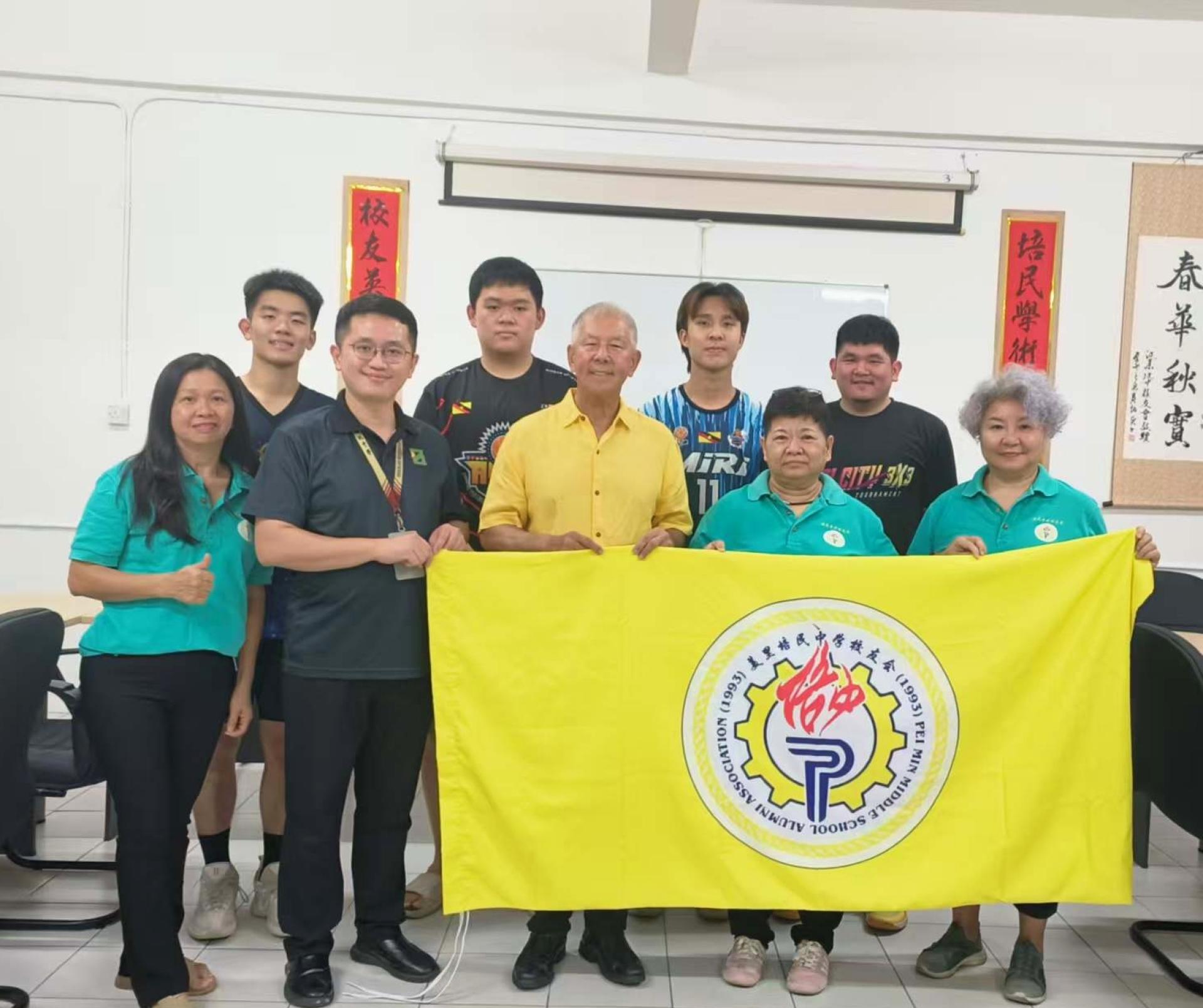 砂旅游部副部长拿督陈超耀（中）授旗予美里培中校友会主席黄金凤（右2）。