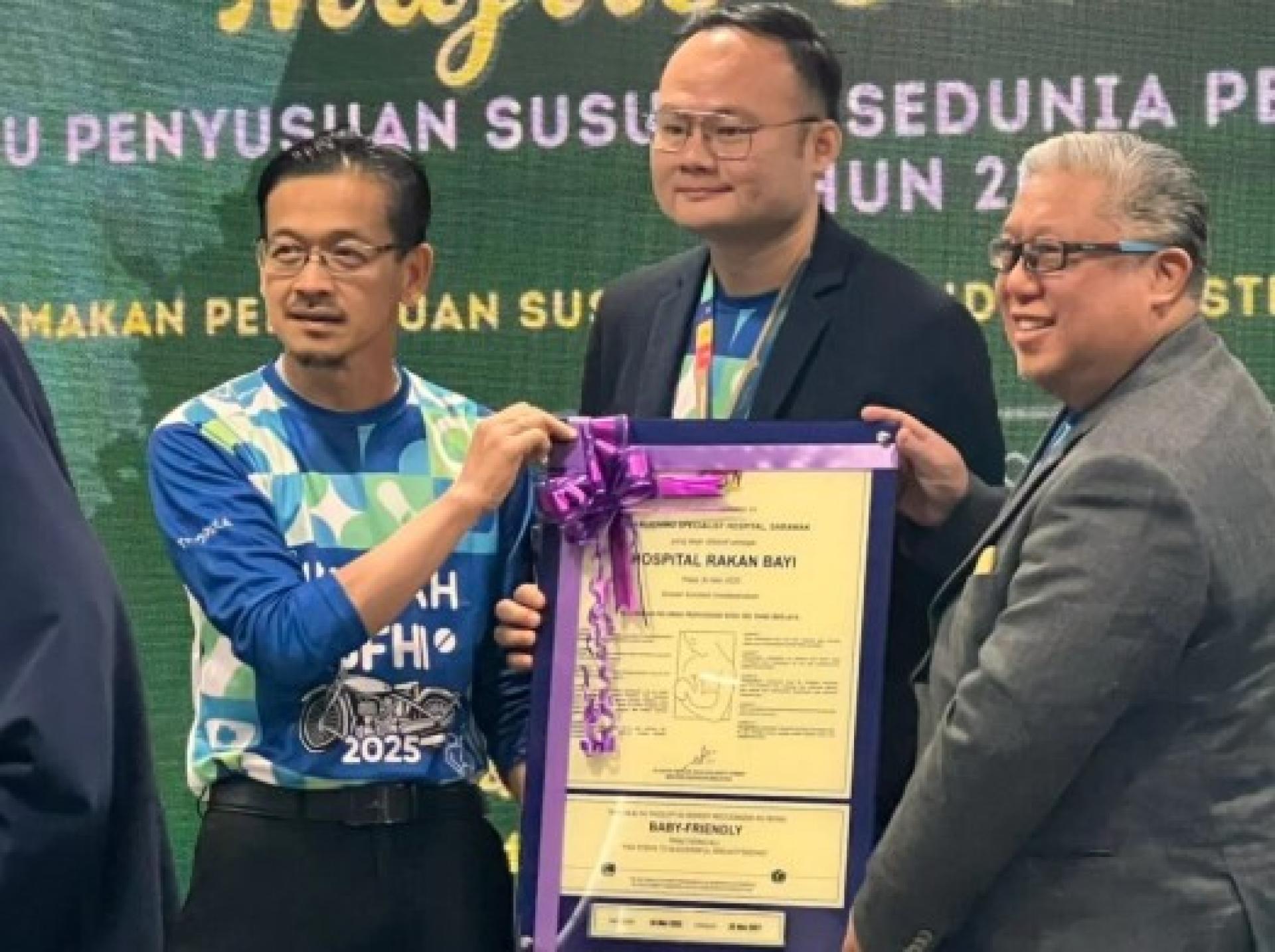 伊斯慕尼博士（左）移交BFHI认证牌匾予Dr. Kenny Yeap Kim Pey（中）。