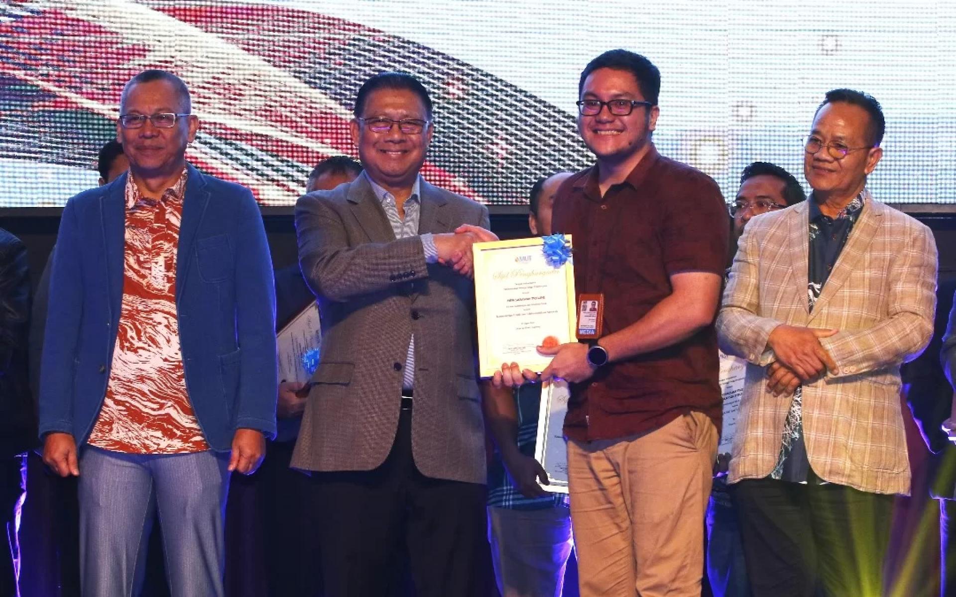 Julaihi (second left) hands over an appreciation certificate to Sarawak Tribune, represented by reporter Neville Timothy Sanders.