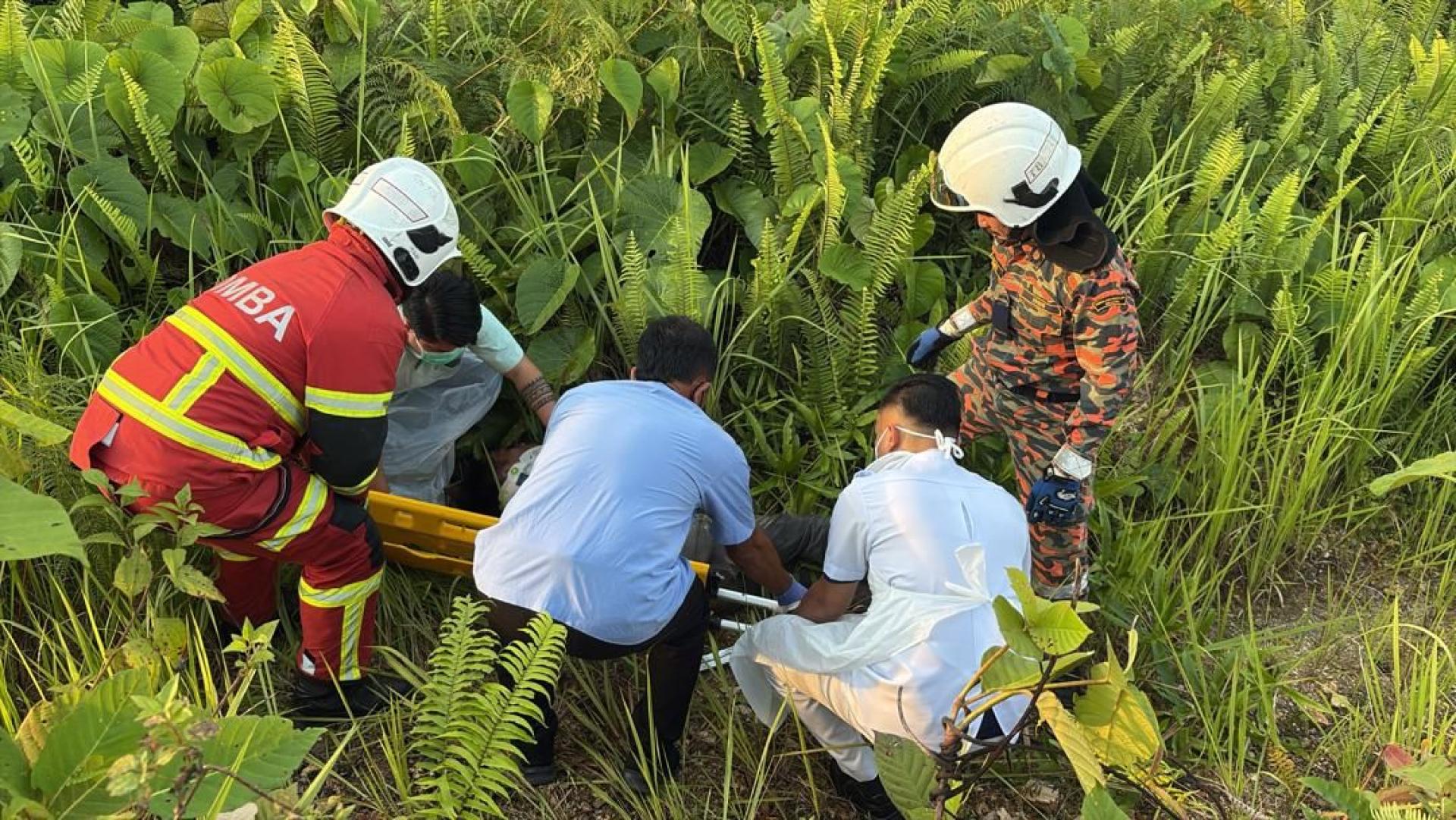 The rescue and medical teams assist the motorcyclist before placing him on a stretcher.