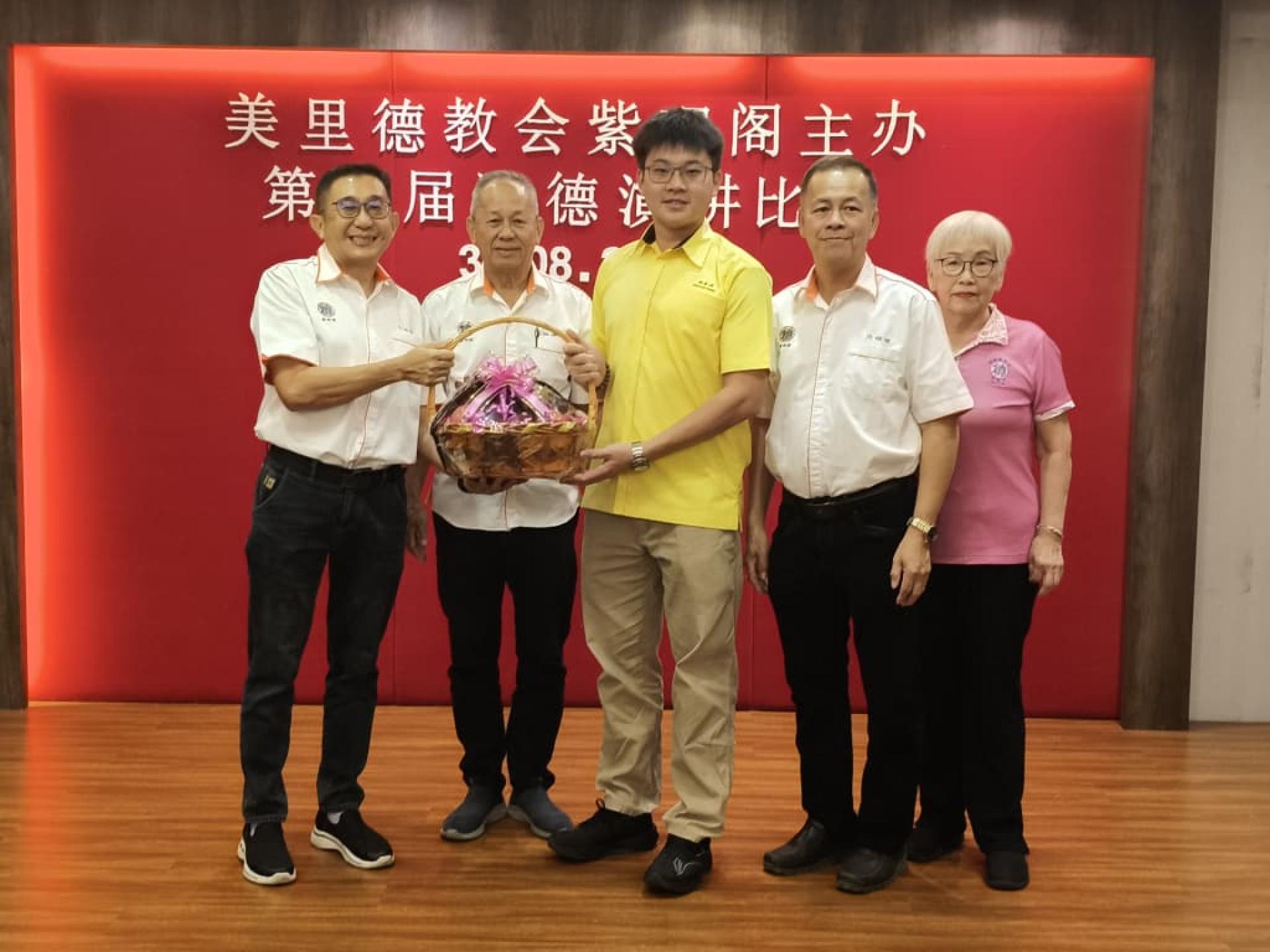 筹备会主席许达伟（左）在美里德教会紫理阁署理阁长何  洪坤（左2）等陪同，赠送水果篮给主宾砂旅游部副部长拿督陈超耀的代  表谢家洪。