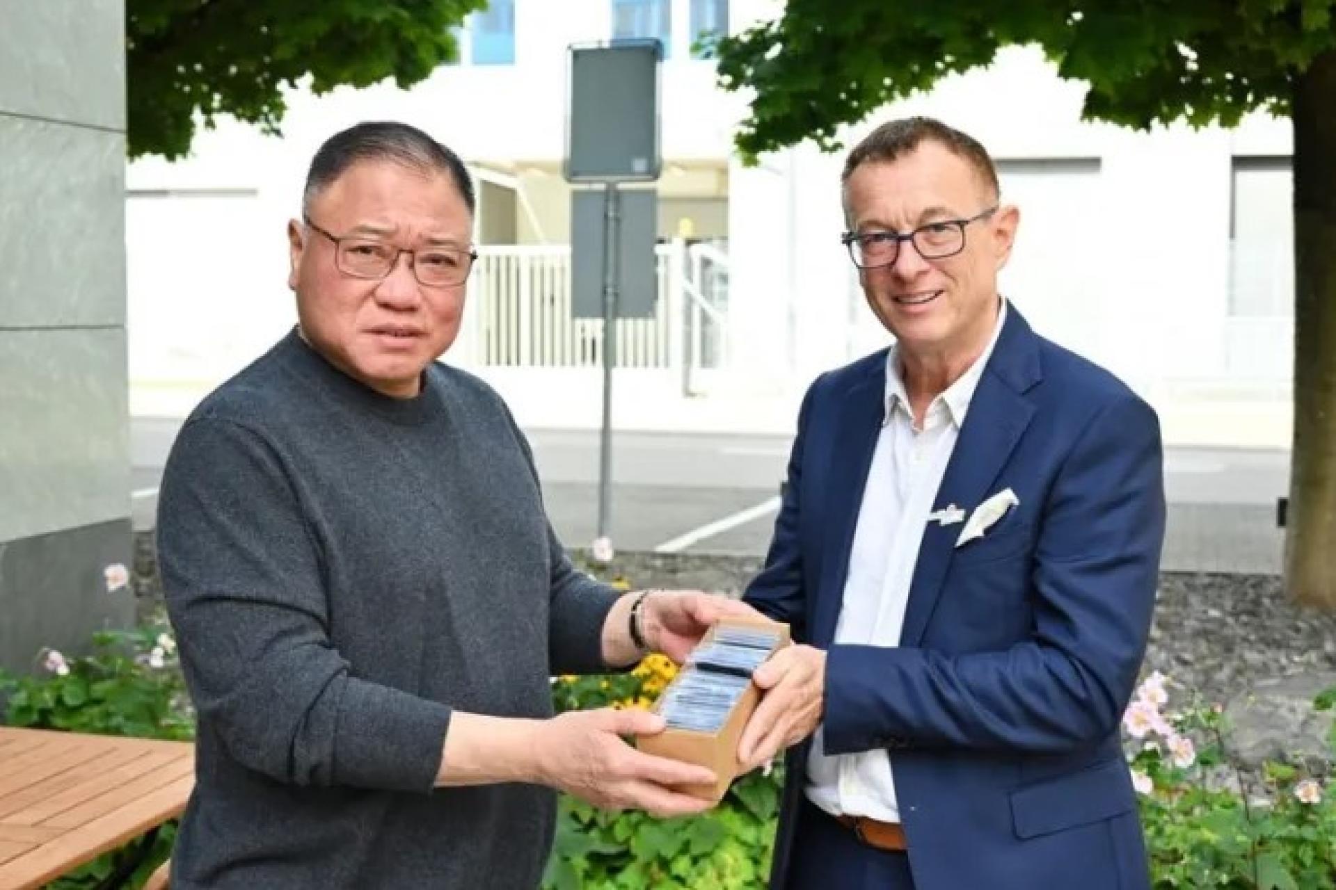 张庆信（左）与罗默（右）在苏黎世会面后互赠纪念品。