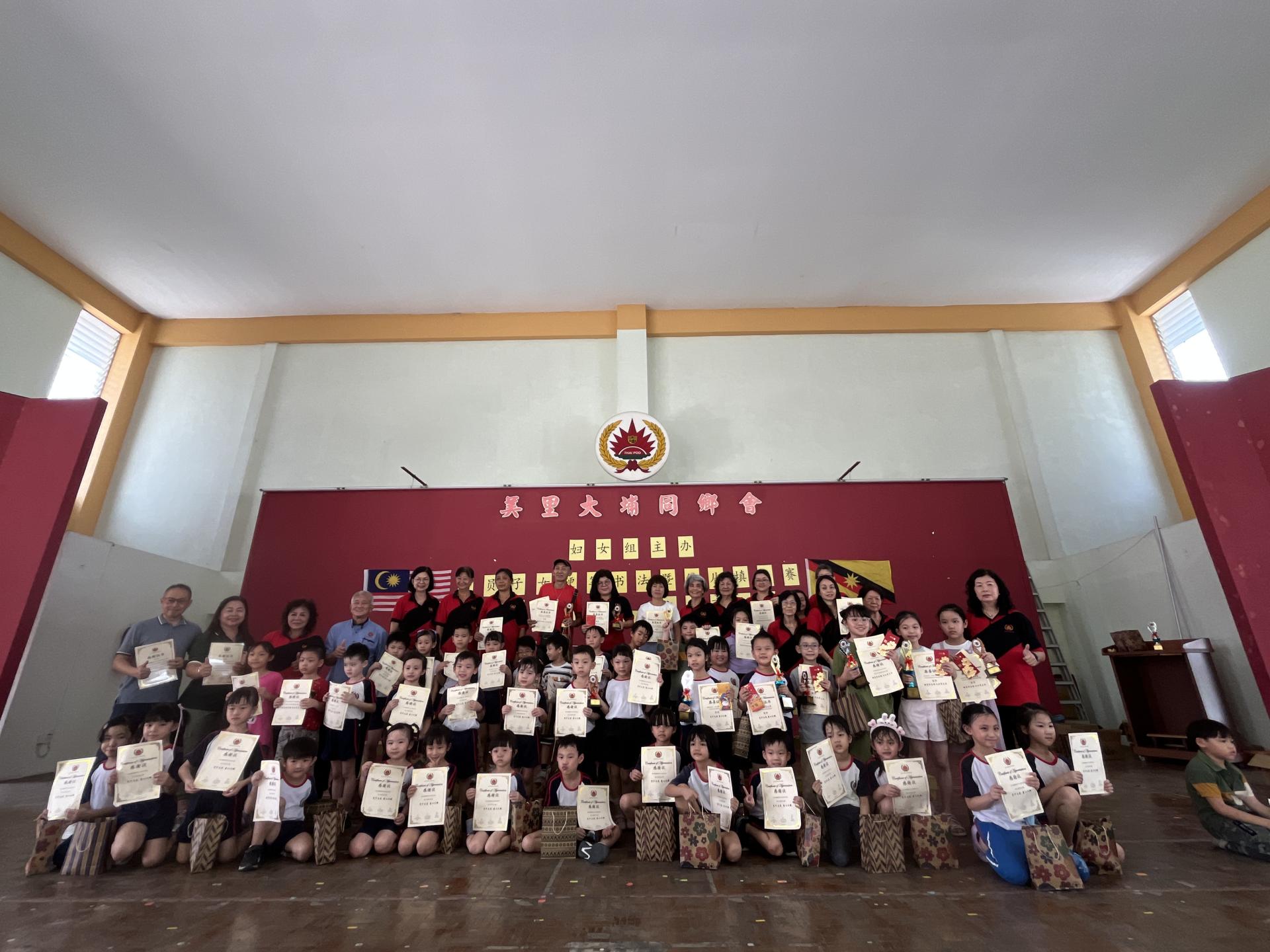 美里大埔同乡会妇女组 “会员子女硬笔书法暨幼儿填色比赛”嘉宾与得奖者合影。中排左3起为妇女组主任甲必丹陈彩萍、主席谢广发及筹备会主席张永淑（右）。