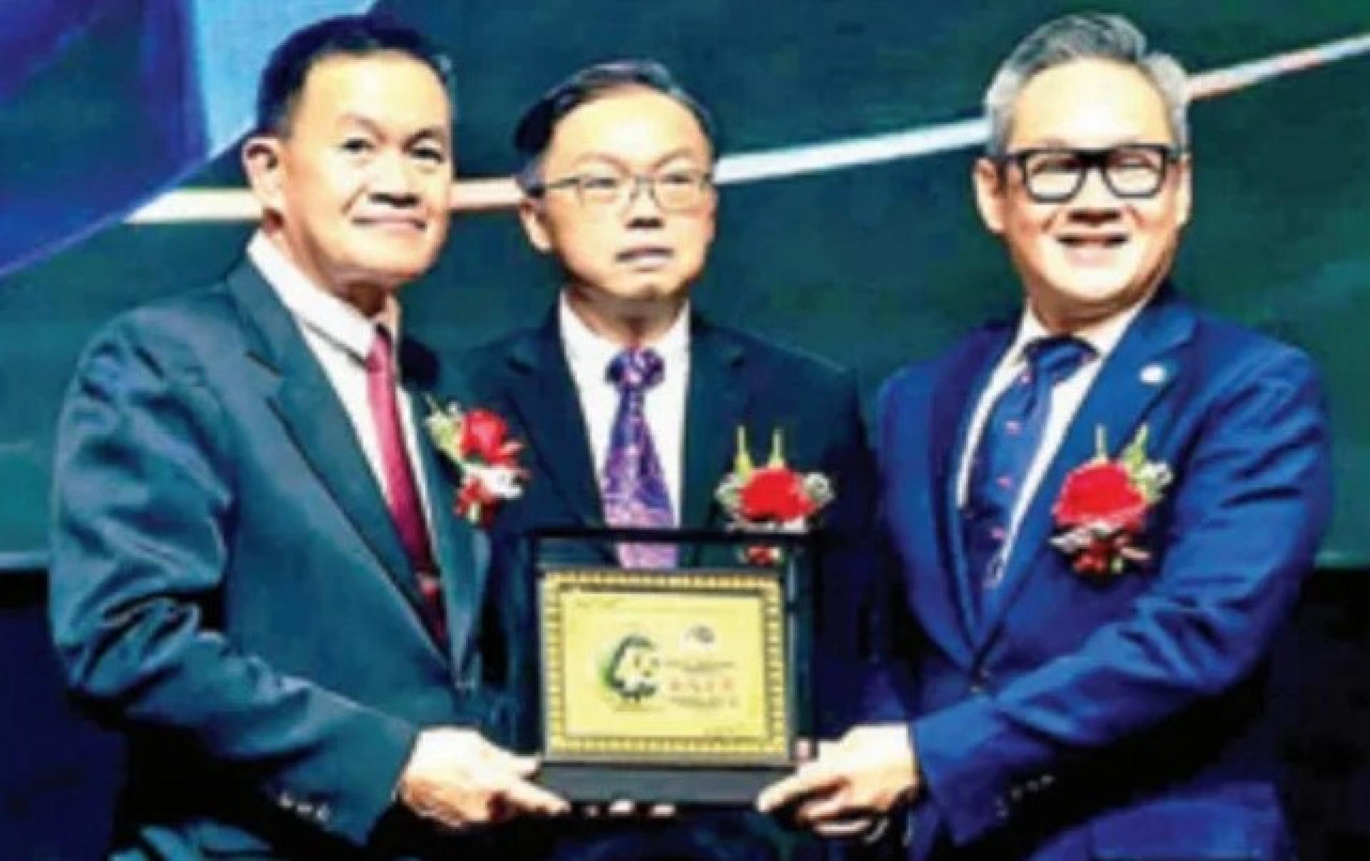 Ngieng Hock Teck（左）移交纪念品予程明智，由Lim King Hong（中）见证。