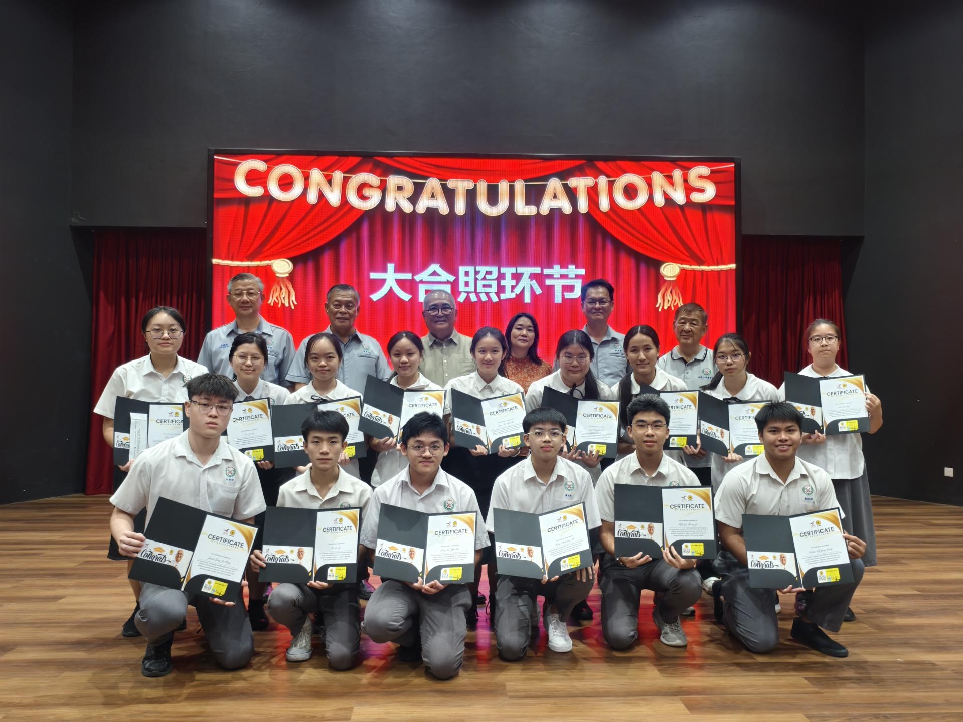 美里培民中学2024年大马教育文凭考试卓越成绩颁奖典礼得奖学生与颁奖嘉宾合影。后排左起  为培中董事秘书林启瑞、董事长许为隆、主宾埔奕区州议员俞小珊市长、校长贝美娇、董事财政沈木桂及副董事  长陈联褒。
