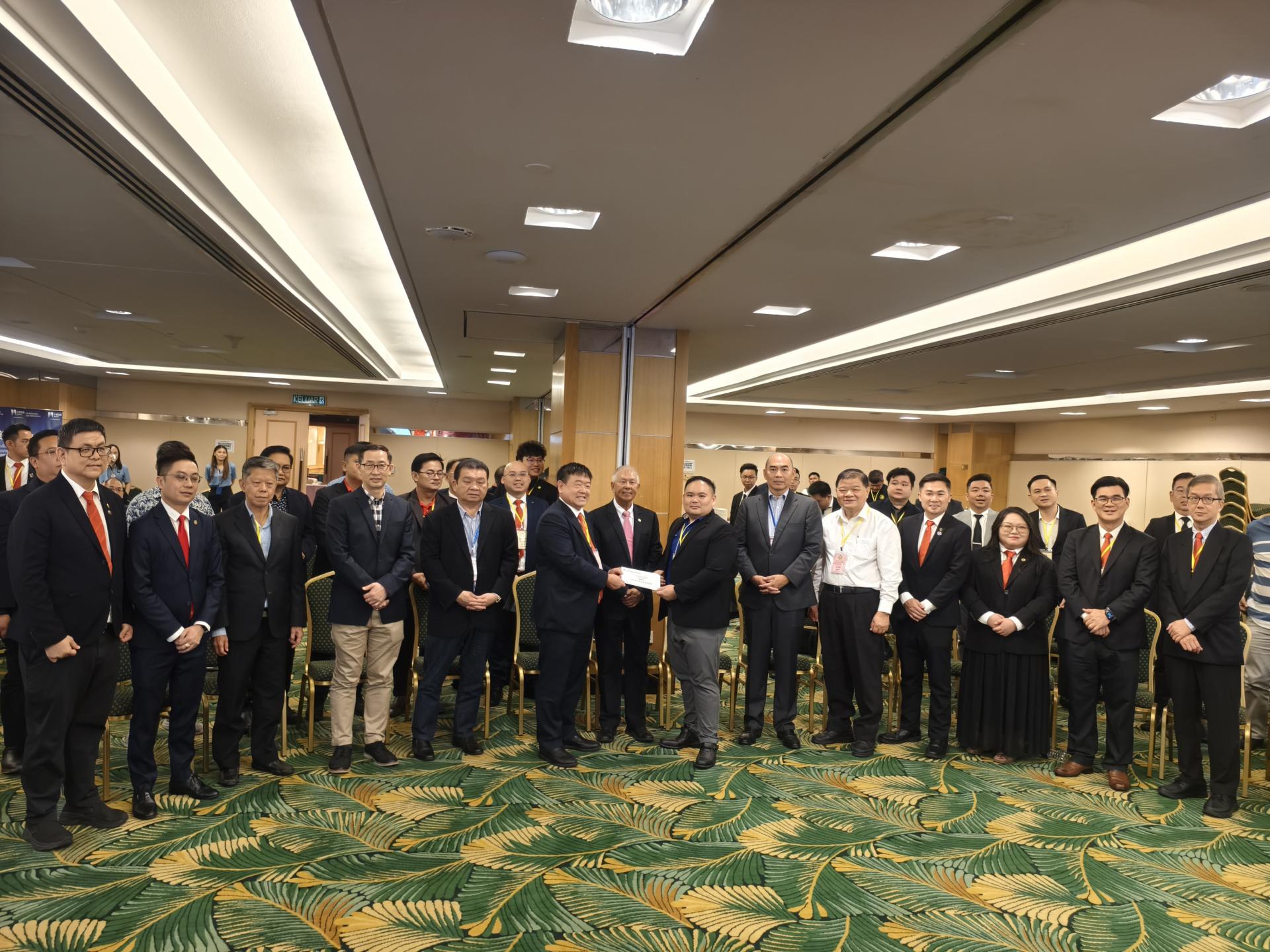 砂拉越中华总商会会长江昌文（左者）在主宾拿督陈超耀副部长（中）的见证，移交奖励金给新成立的青商团，作为他们开展活动的经费支持。