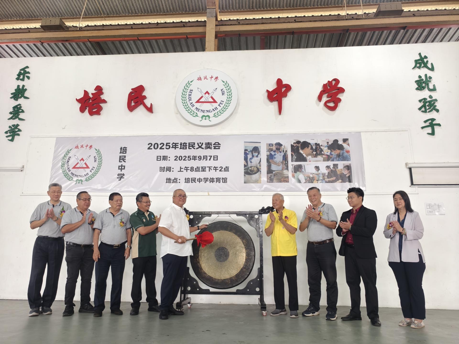 主宾俞小珊市长为2025年“情牵培中”义卖会主持开幕鸣锣开幕仪式。右起为校长贝美娇、美里  国会议员赵俊文的代表邹梓建、培中董事长许为隆、砂旅游部副部长拿督陈超耀，以及筹备会主席兼家教联谊  会主席张海强（左4）等。