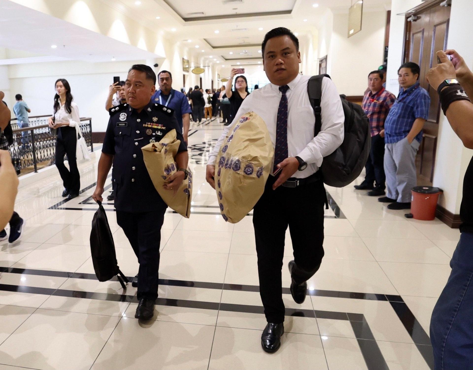 警官抱模拟人偶出庭，还原坠落经过。