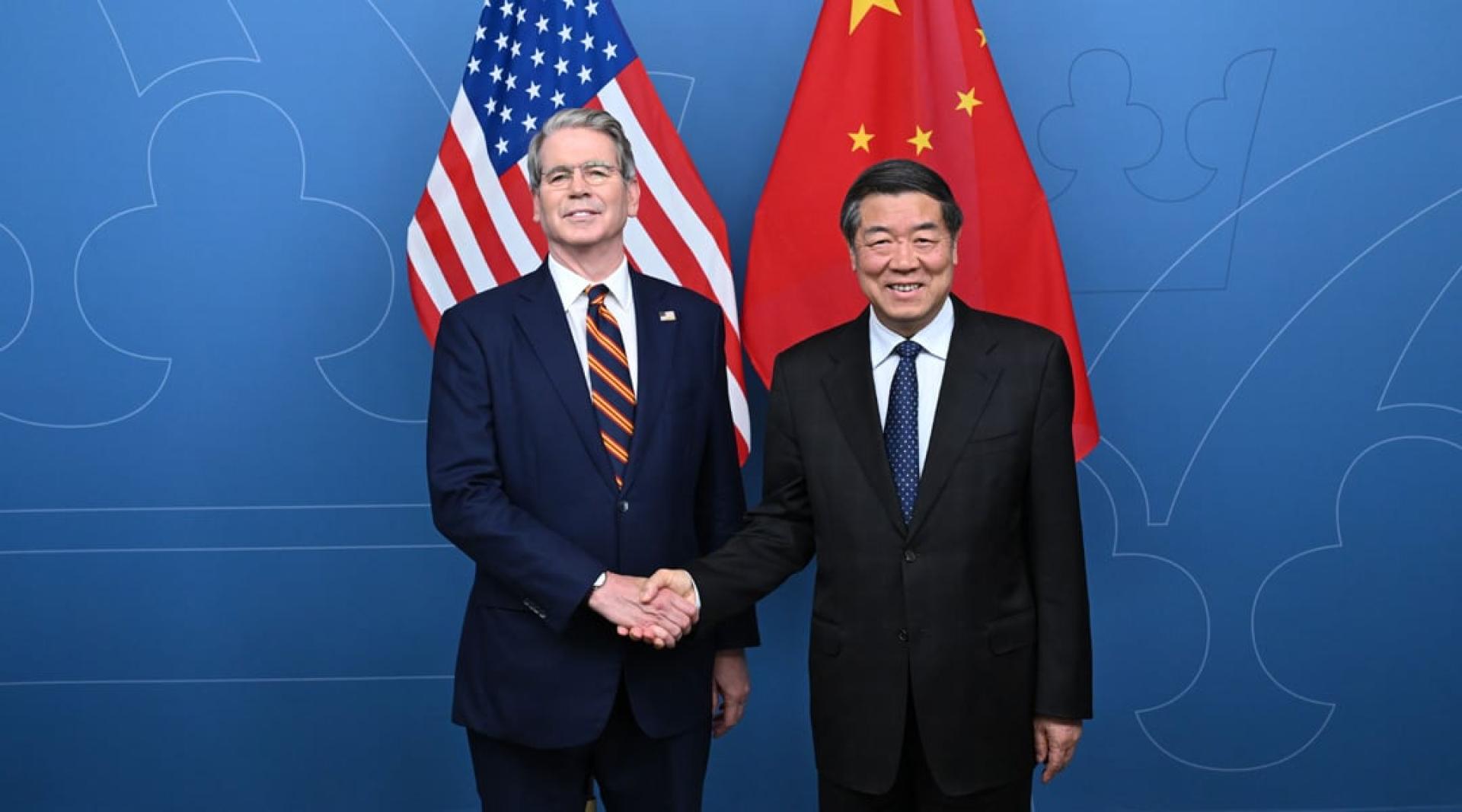 中国国务院副总理何立峰（右）与美国财政部长贝森特于今年7月在斯德哥尔摩举行的第3轮会议前握手。（新华社档案照）