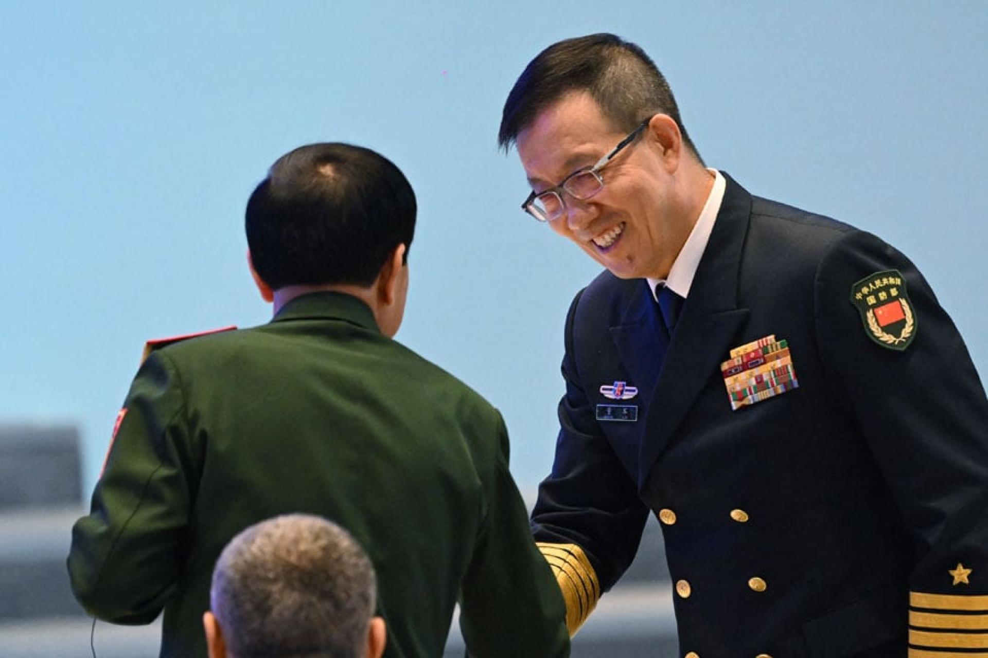 中国国防部长董军（右）18日与越南国防部长潘文江（左）握手。