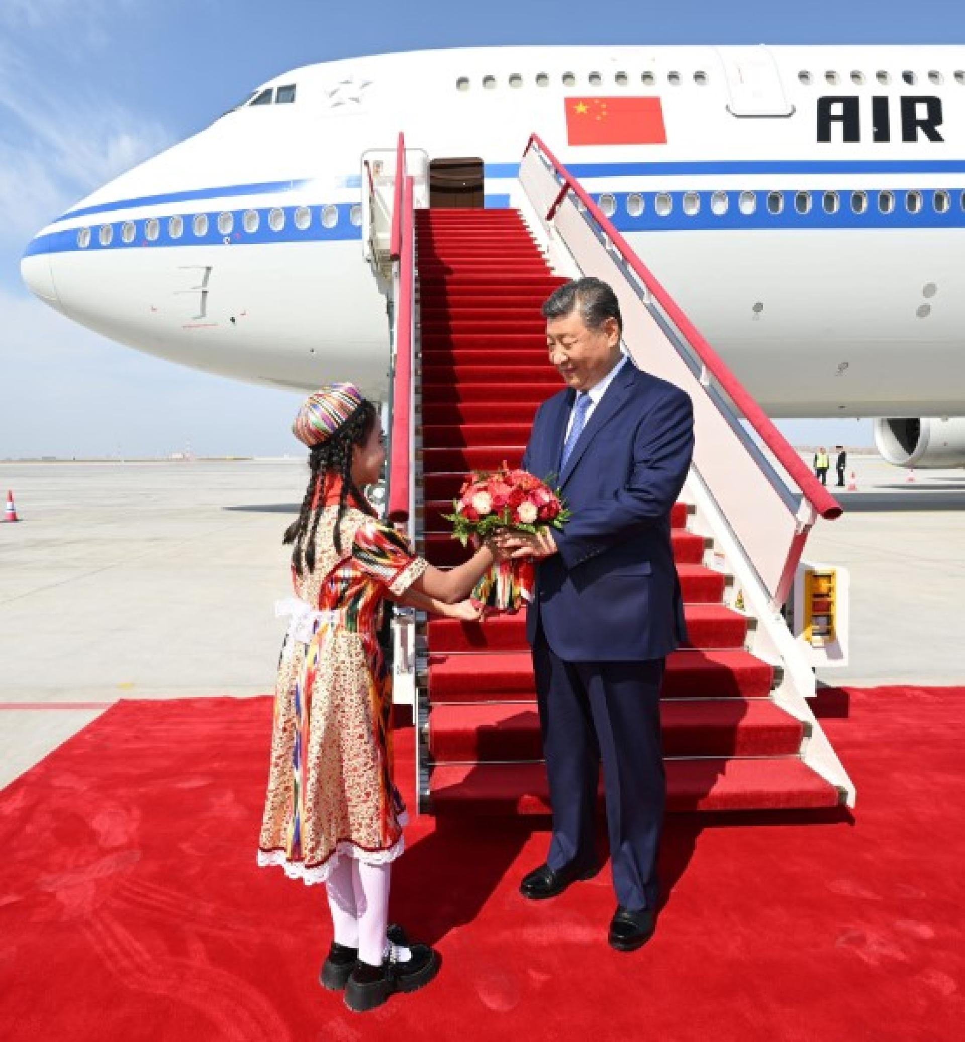中国国家主席习近平23日乘专机抵达乌鲁木齐后，少先队员向习近平献花。