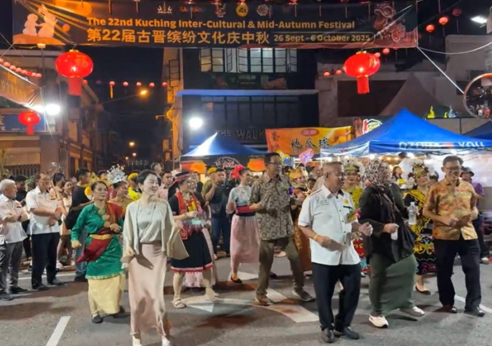 阿都卡林（中）于2025年9月26日为古晋缤纷文化庆中秋主持开幕后，与众人一同随《Biar Bekikis Bulu Betis》乐曲跳起poco-poco舞。