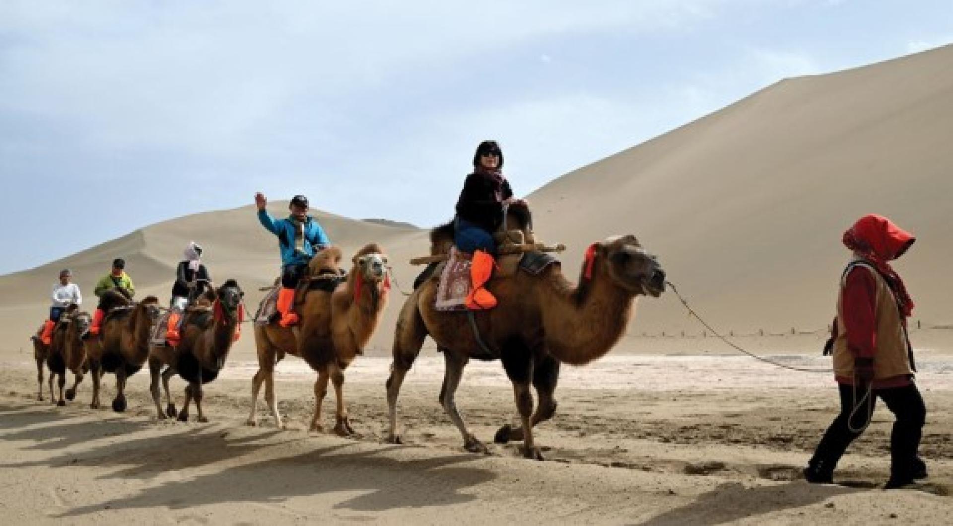 中国国庆、中秋双节将至，节日氛围日益浓厚，多地景区游客增多。图为游客25日游览敦煌市鸣沙山月牙泉景区。