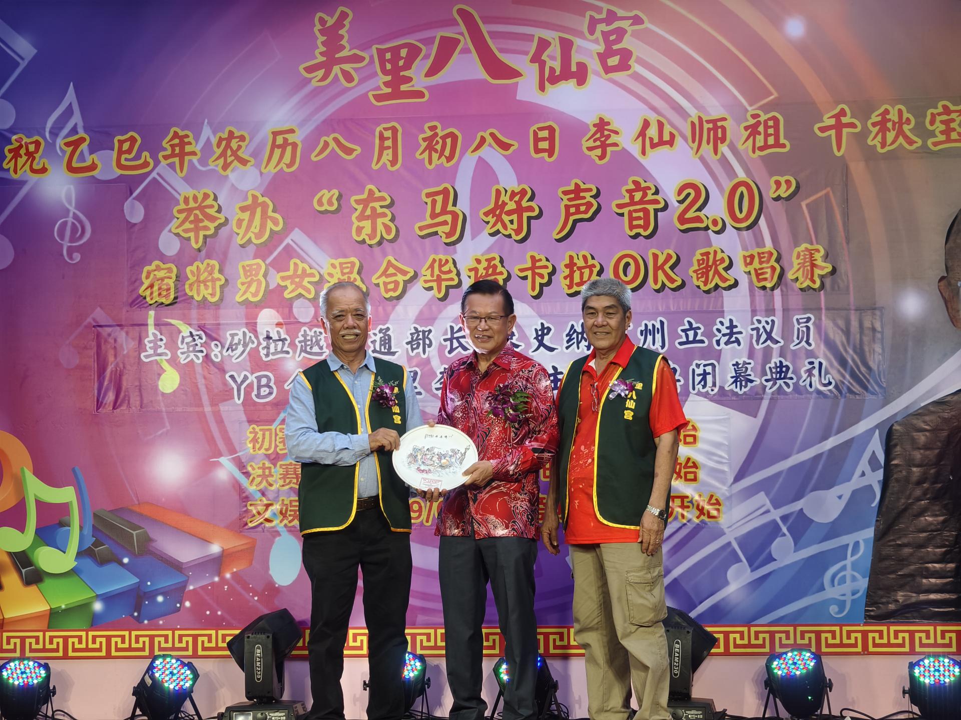 名誉主席黄明坤（左）赠送纪念品予主宾拿督斯里李景胜。右为筹备会主席郑少轩。